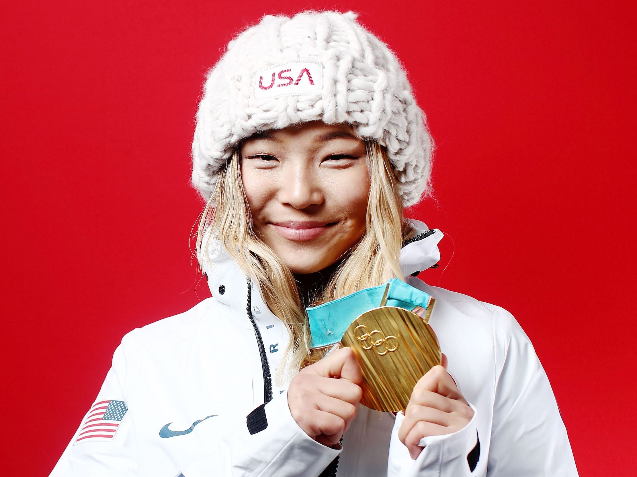 Chloe Kim poses with her Olympic gold medal.