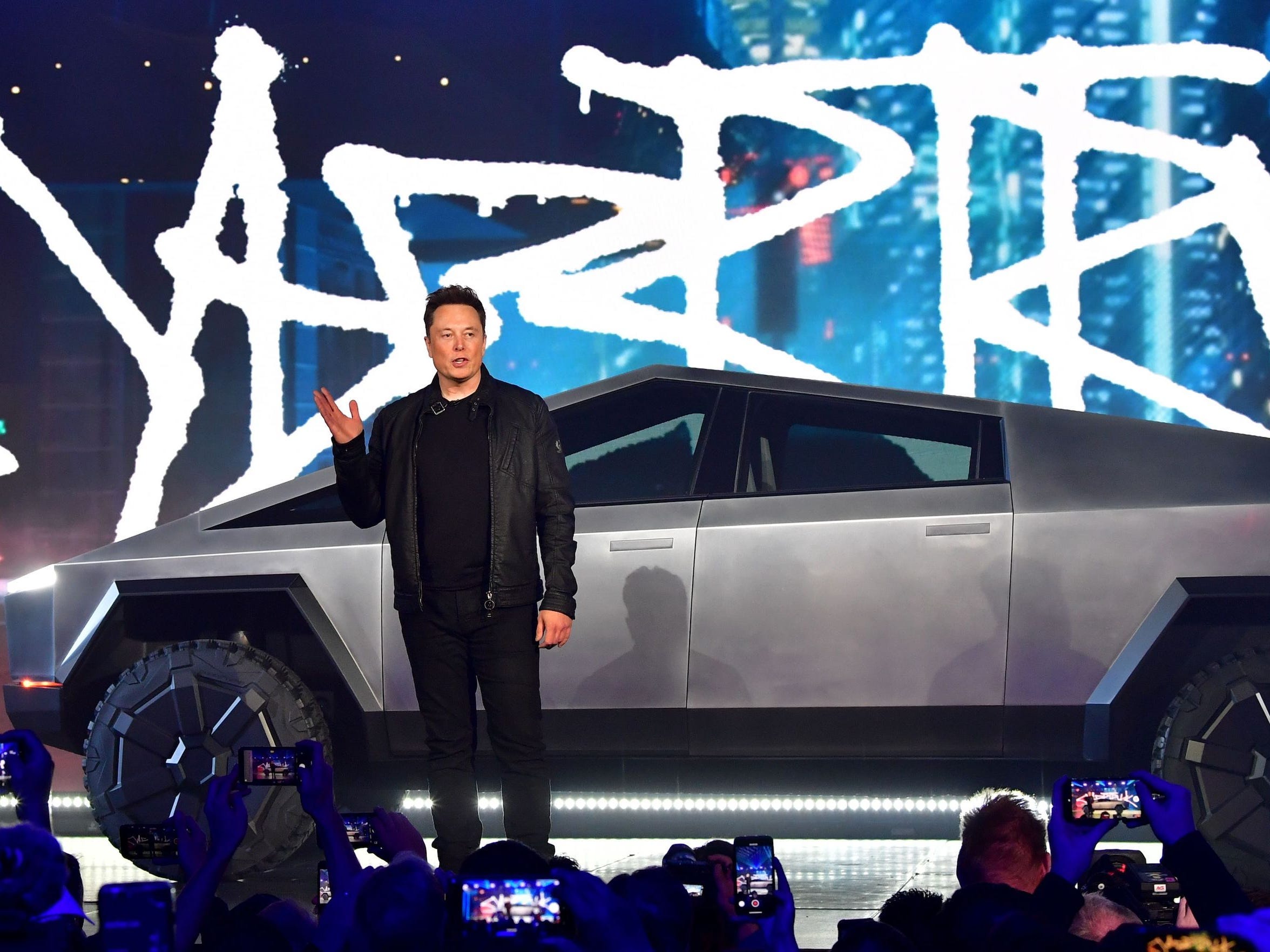 Tesla CEO Elon Musk stands in front of the company's Cybertruck.