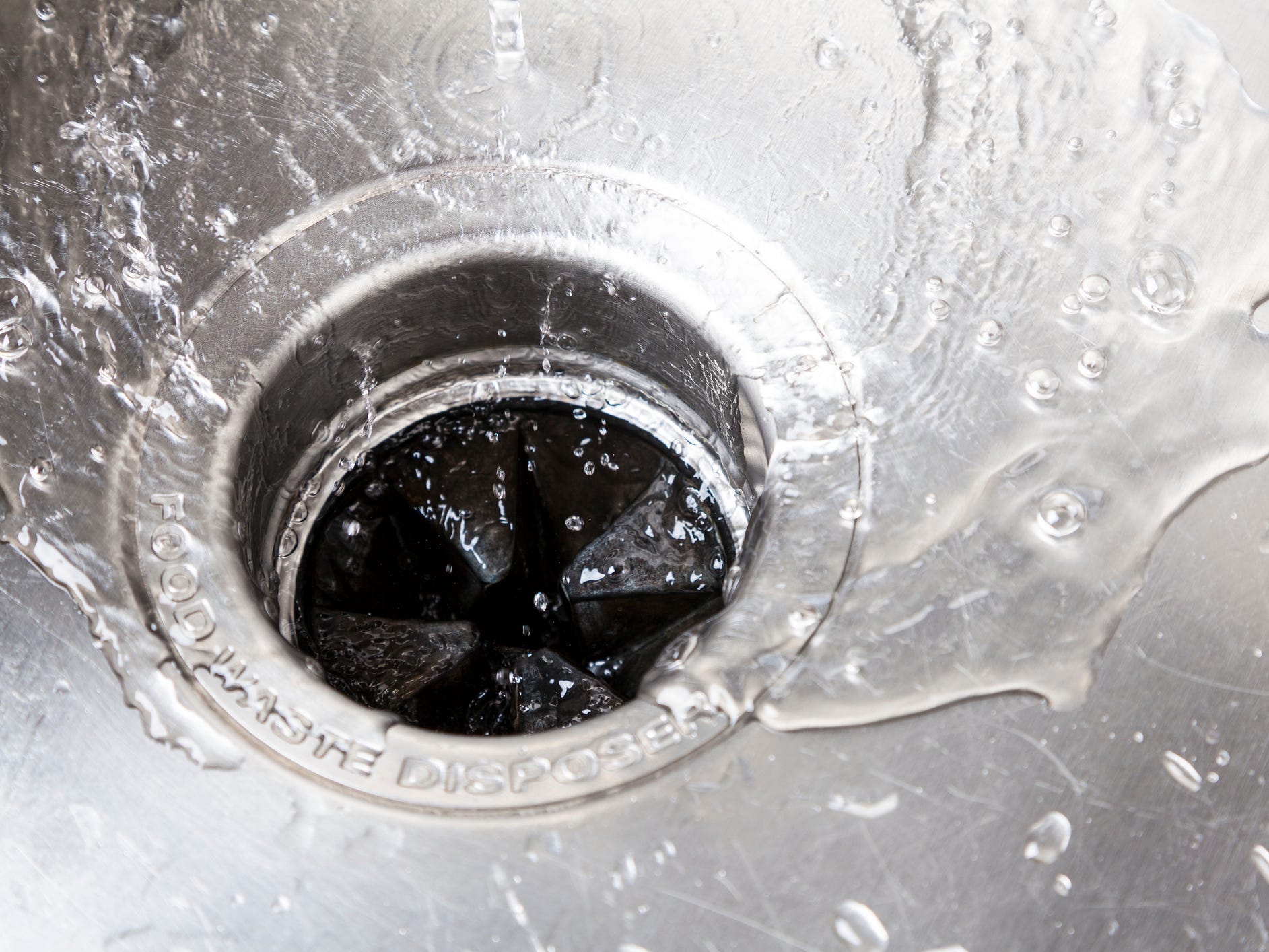 Water running down a garbage disposal sink drain