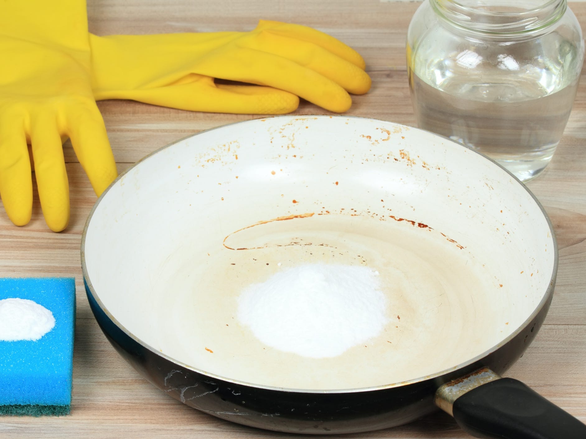 A dirty pan with baking soda inside ready to be scrubbed