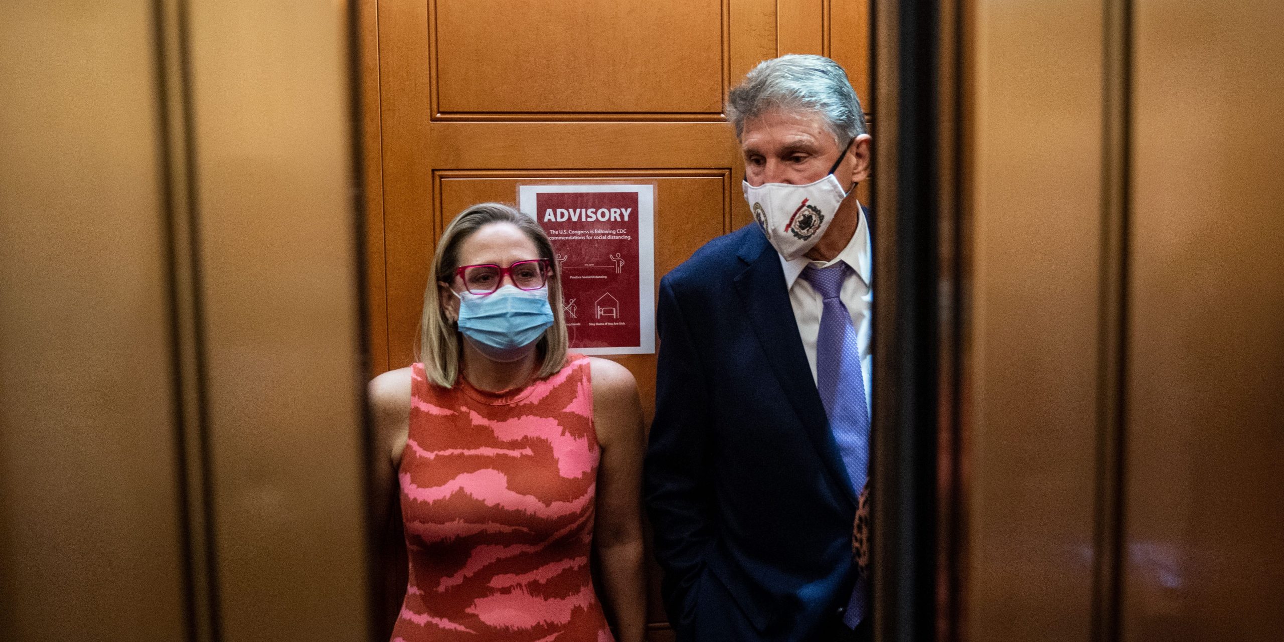 Democratic senators Kyrsten Sinema and Joe Manchin talk in a Senate elevator.