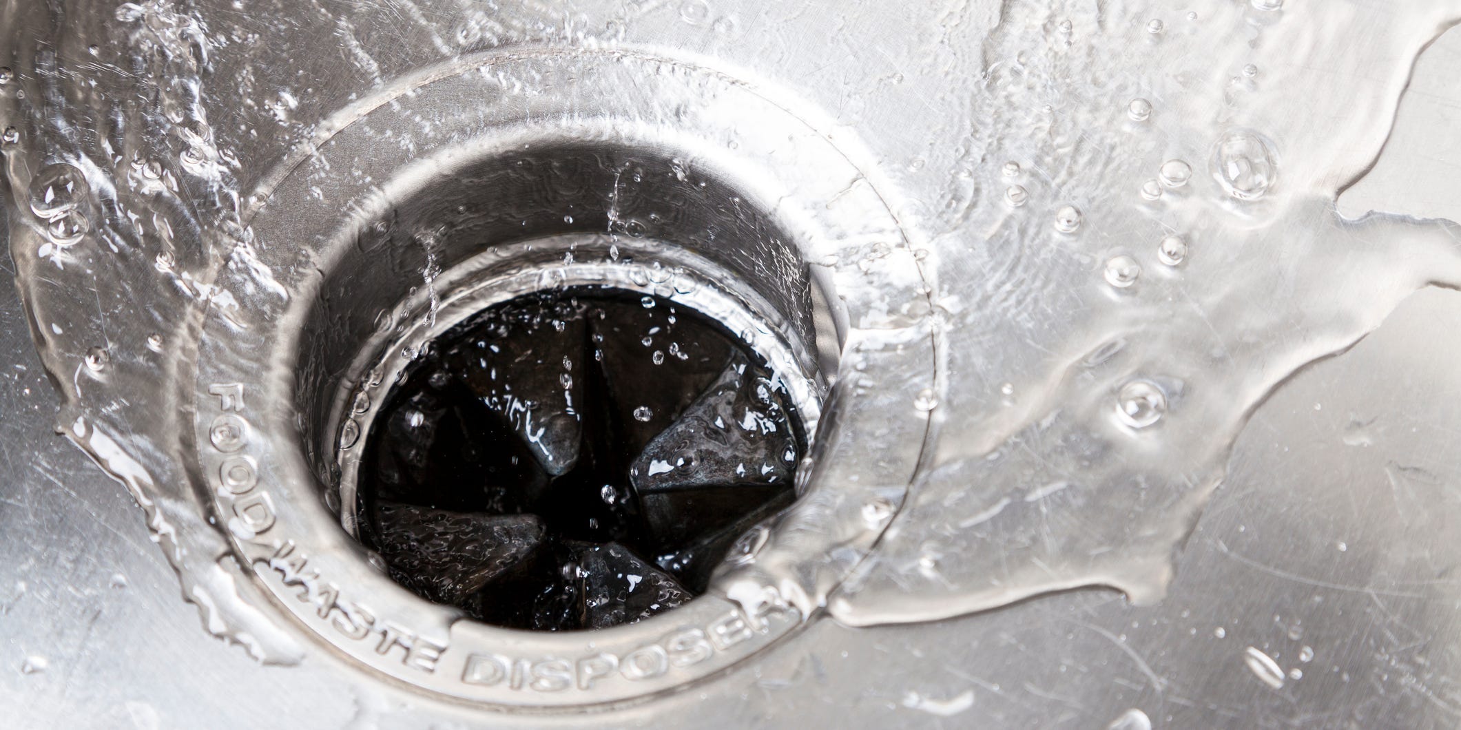 Water running down a garbage disposal sink drain