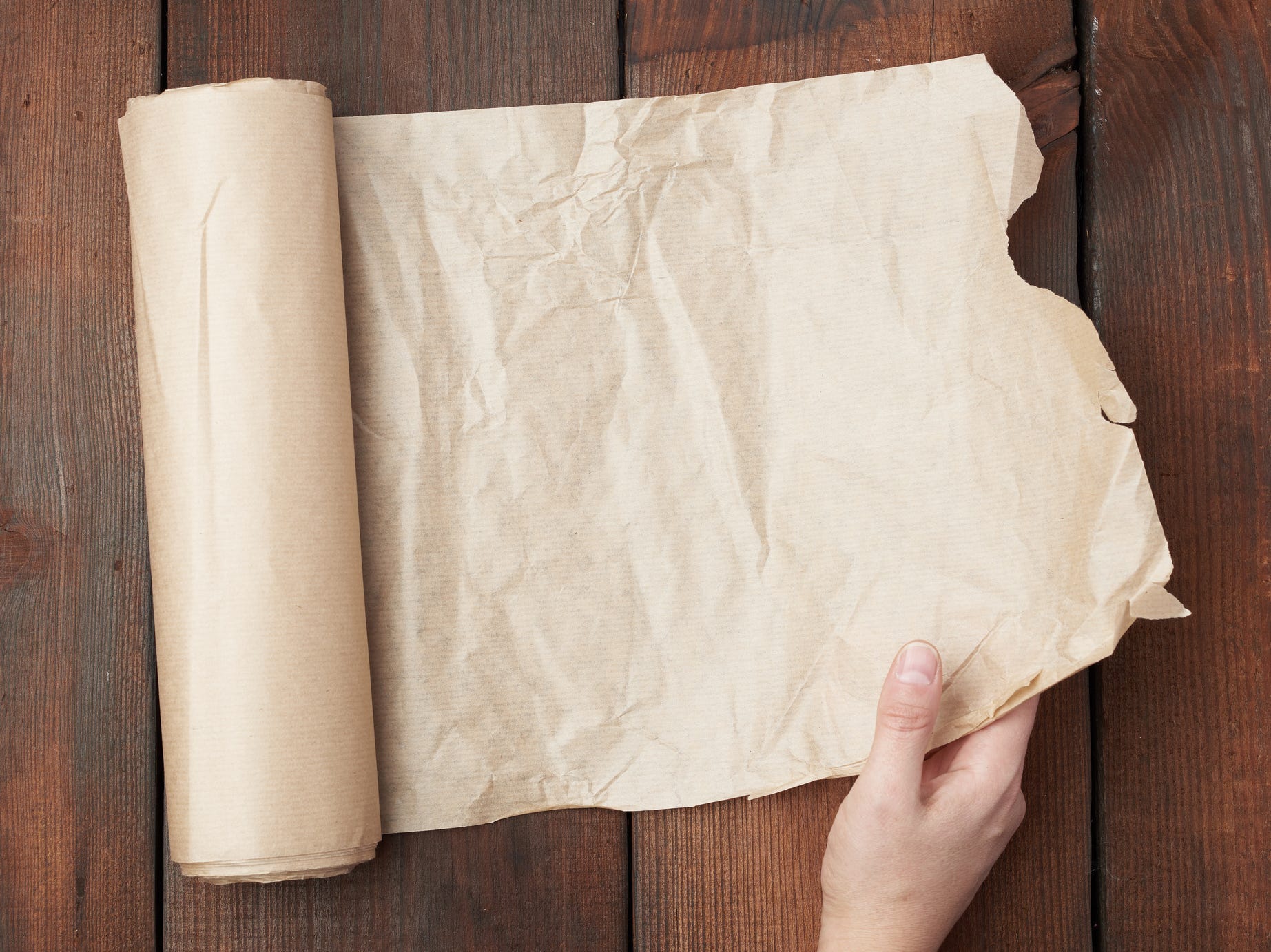 Person holding parchment paper from a parchment paper roll