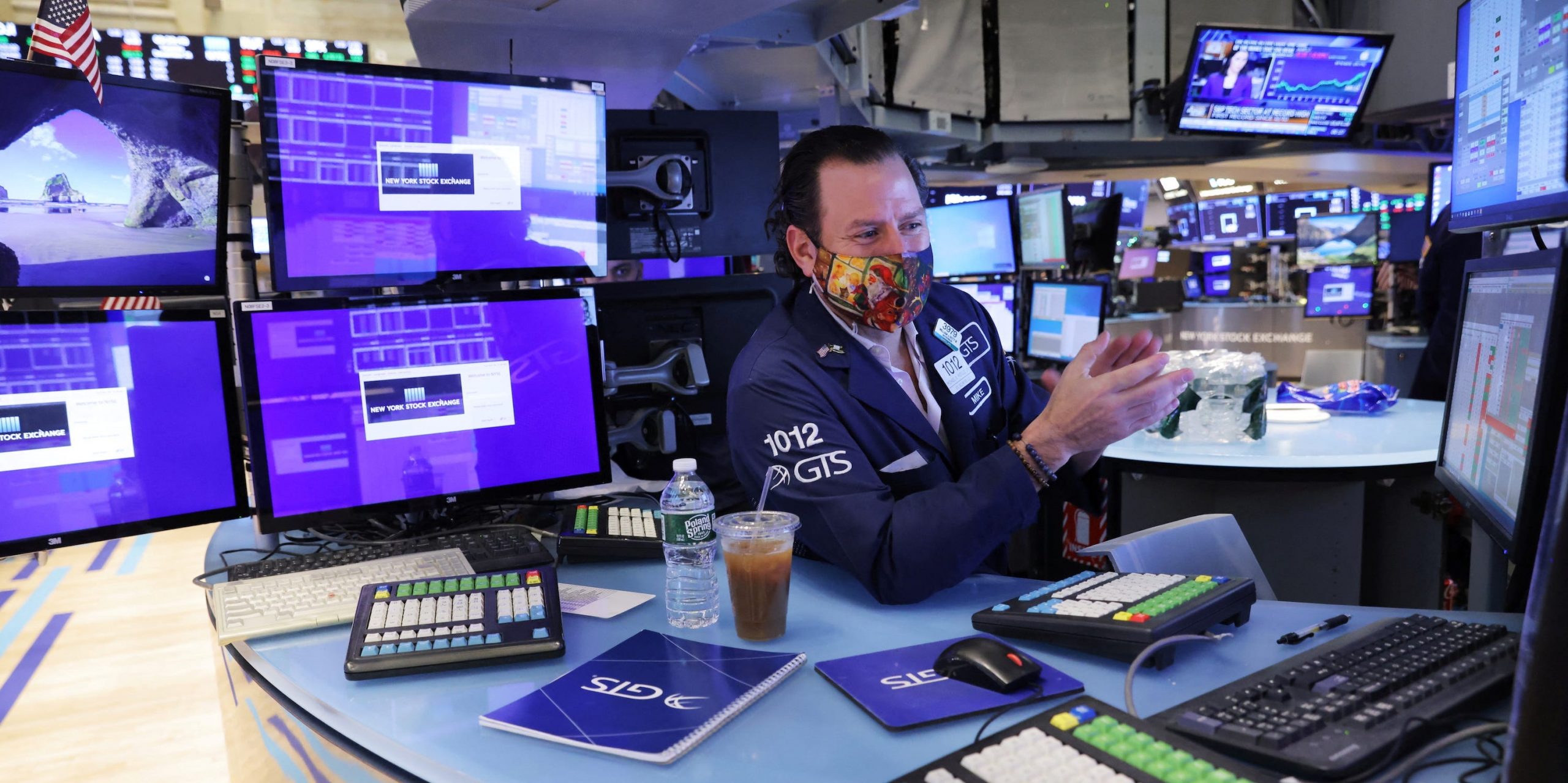 Trader with screens on NYSE floor clapping