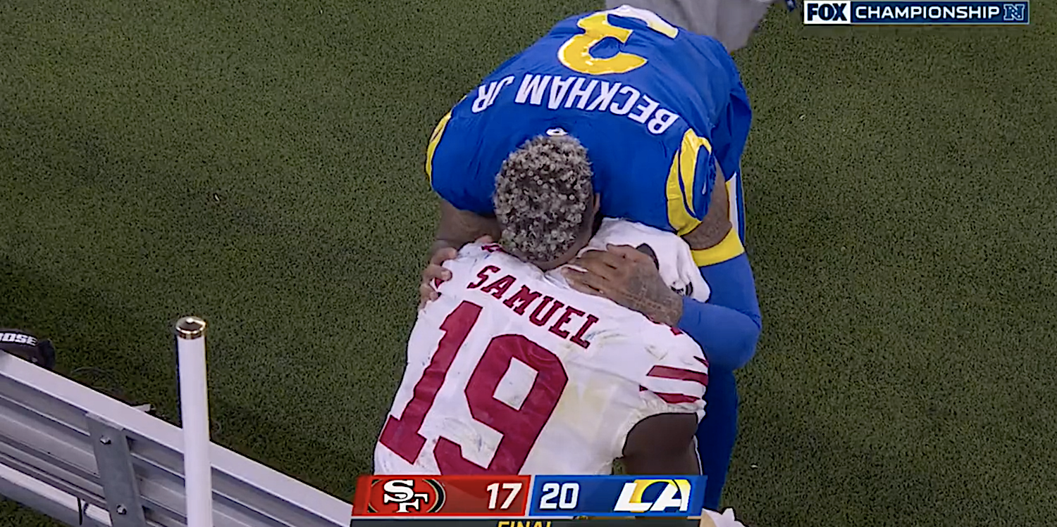 Odell Beckham Jr. leans over and consoles Deebo Samuel, who sits on the bench with a towel on his head.