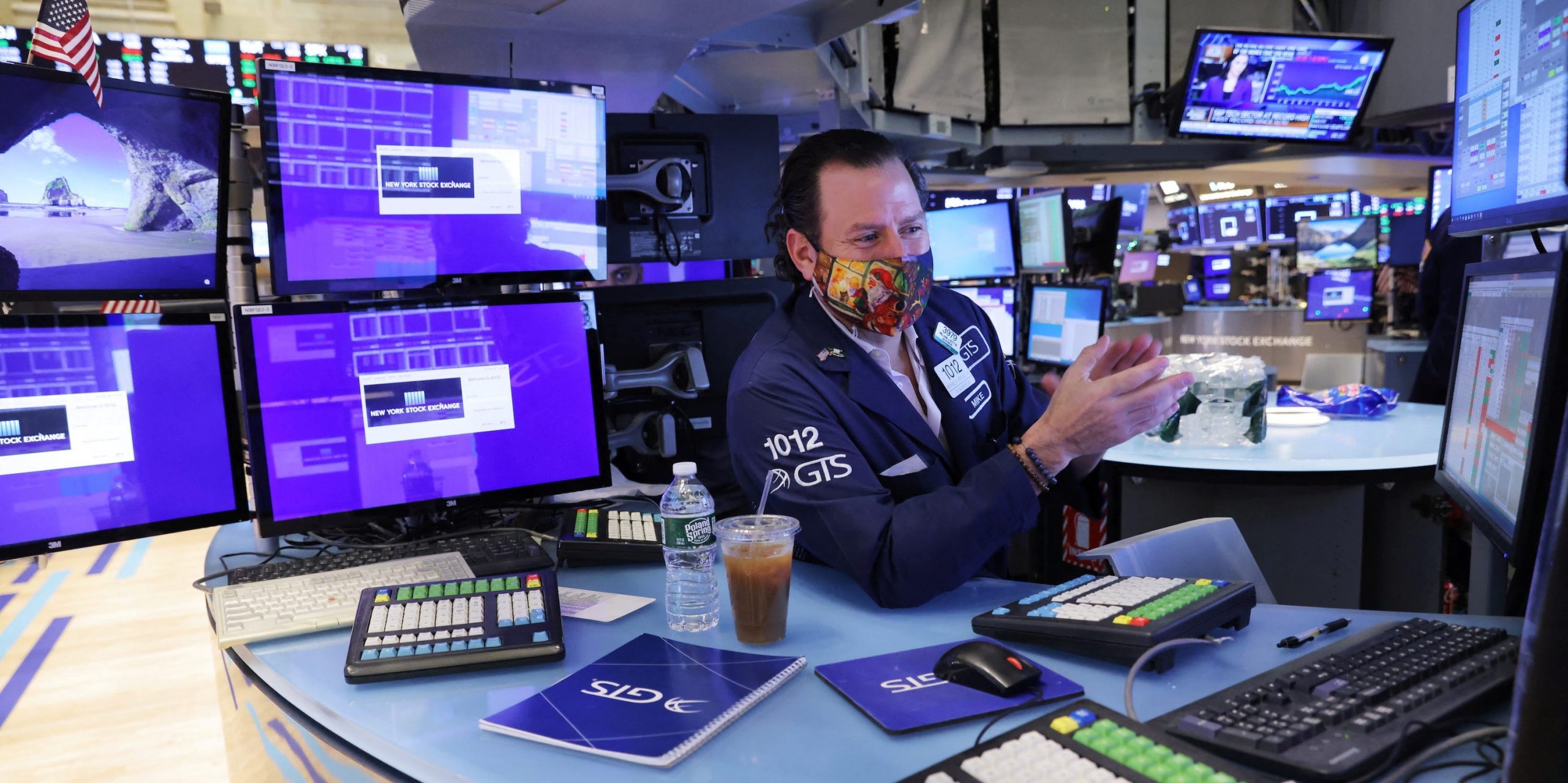 Trader with screens on NYSE floor clapping