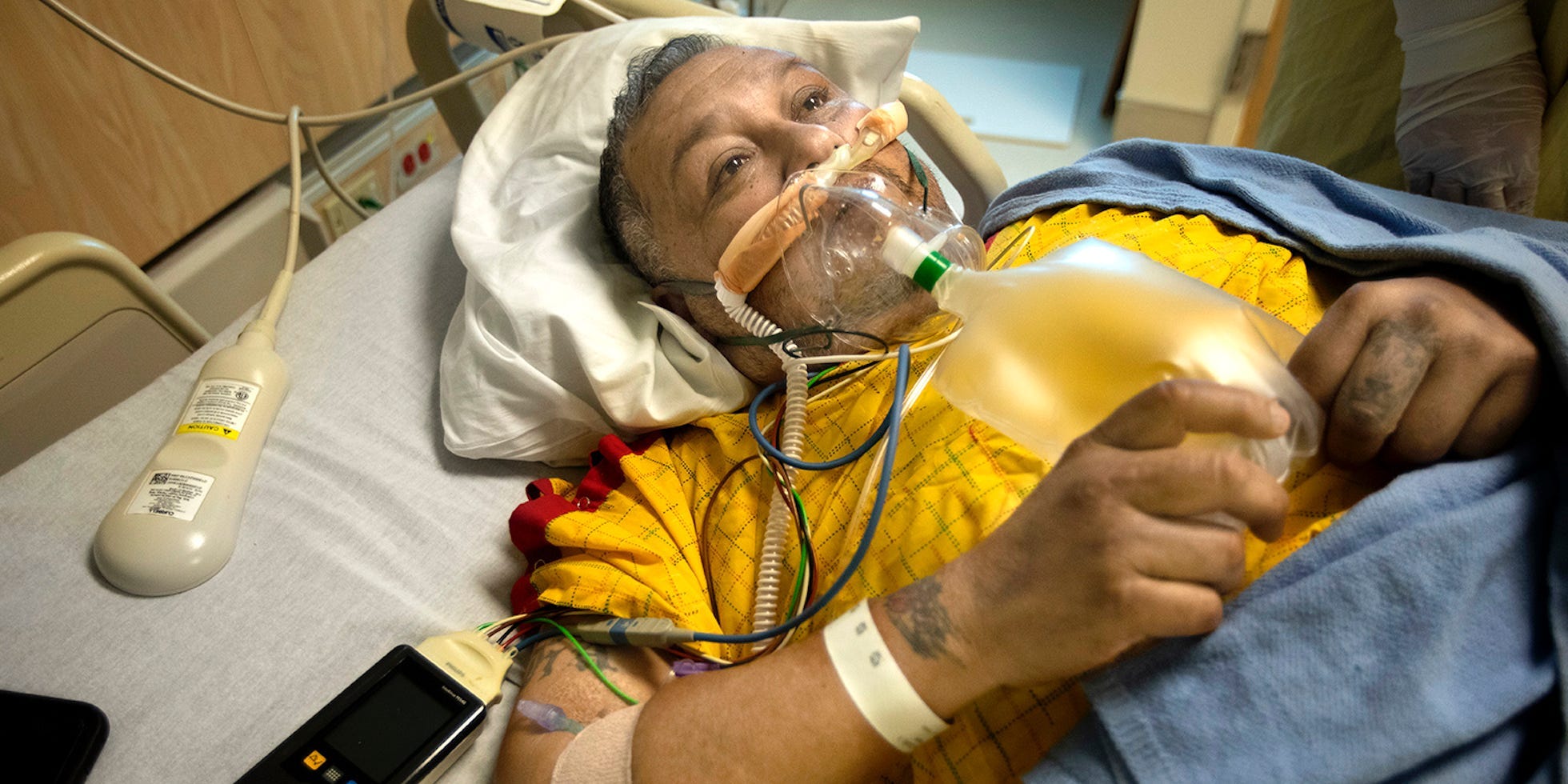 man on ventilator for covid, looking up in his hospital bed