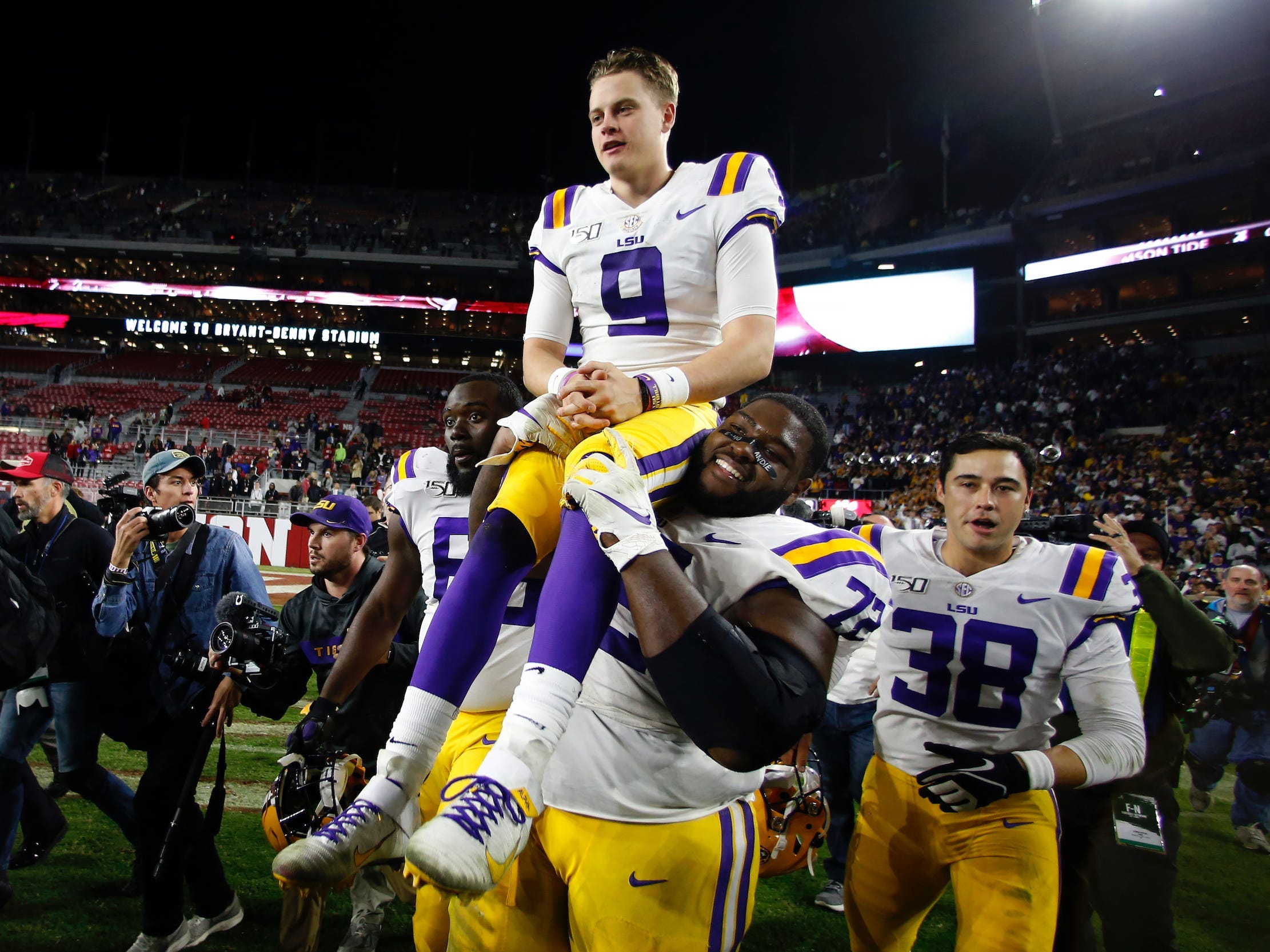 Tyler Shelvin carries Joe Burrow off the field at Alabama's Bryant-Denny Stadium.