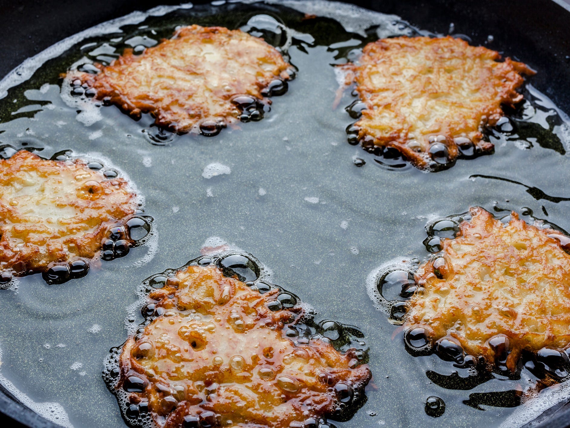 Shallow frying of latkes close up