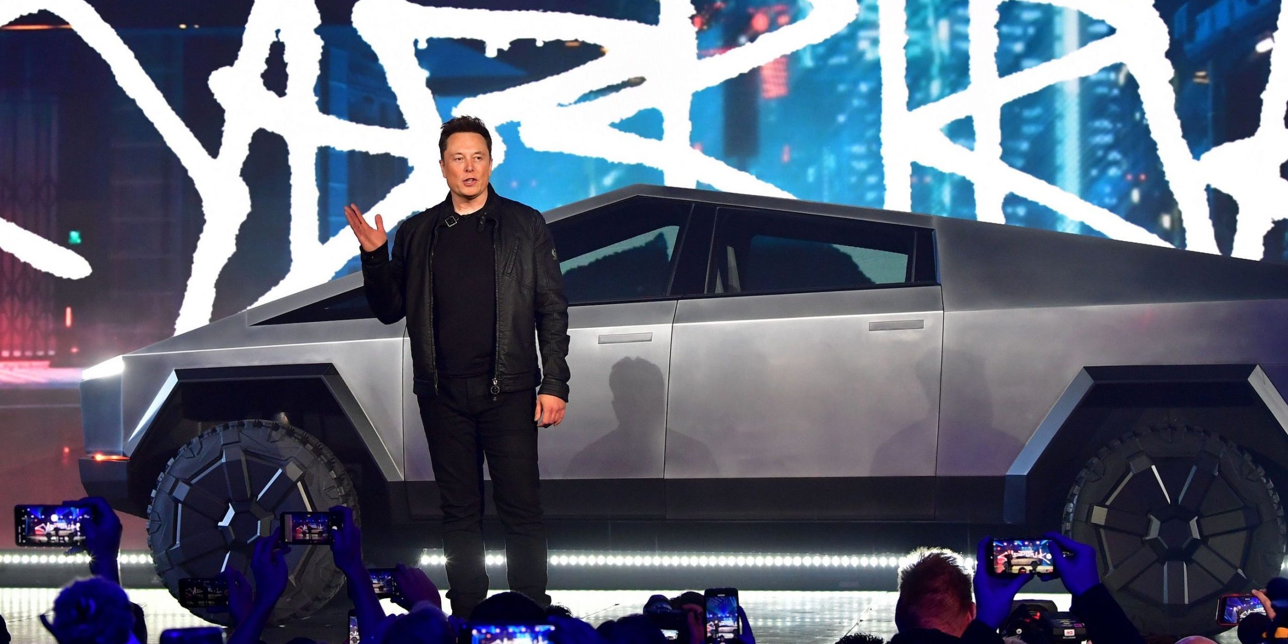 Tesla CEO Elon Musk stands in front of the company's Cybertruck.