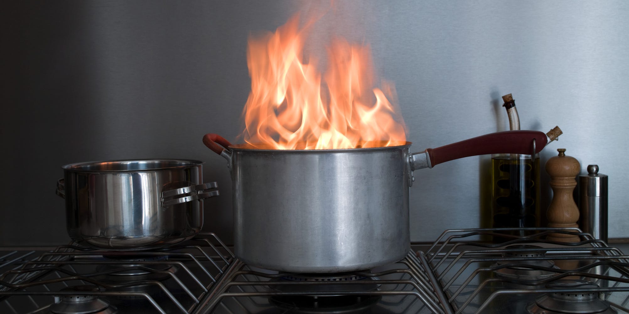 A pot on a stove with flames coming out of it