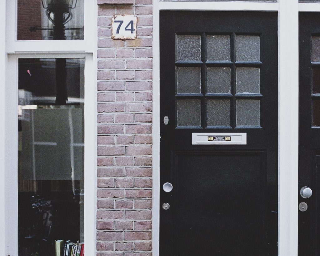 Een Amsterdamse voordeur met nee-nee sticker