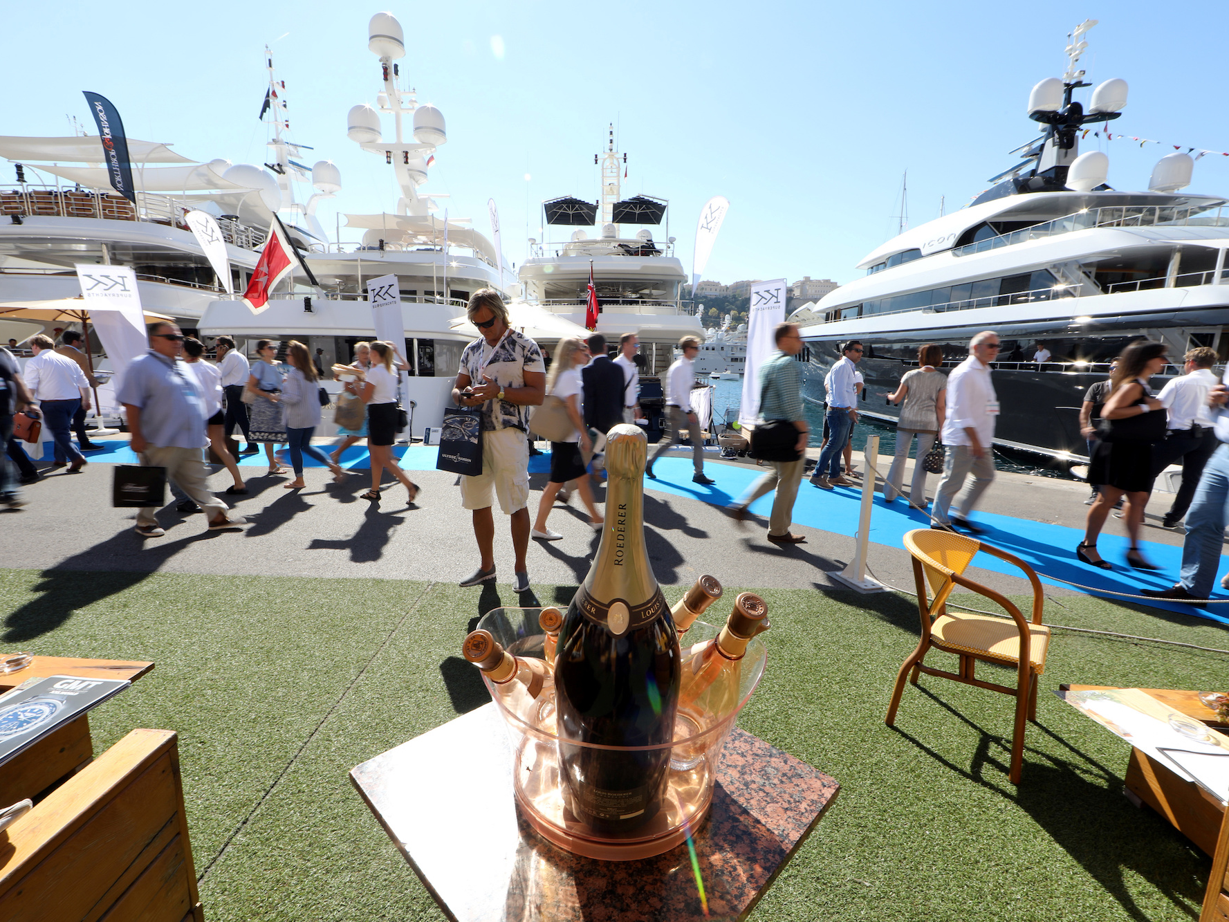 Visitors walk past luxury boats as they attend the 26th Monaco Yacht show.