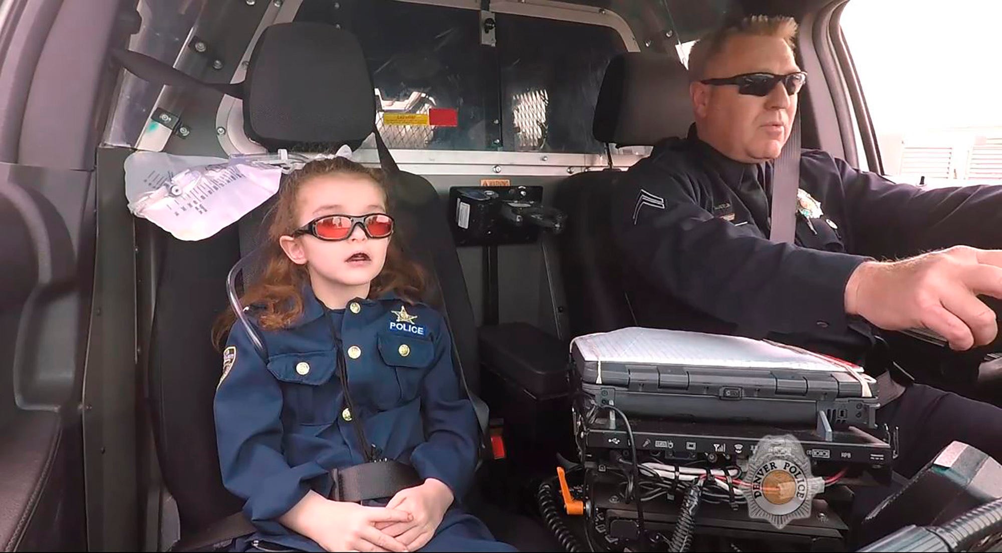 In this image made from April 2017 video provided by the Denver Police Department, Olivia Gant, who was 6 years old at the time, rides with Cpt. Tim Scudder on a call in Denver. On Monday, Oct. 21, 2019, a Douglas County, Colo., grand jury indicted the mother of Olivia Gant in connection with the little girl's 2017 death. Olivia's mother, Kelly Renee Turner, faces 13 charges, including first-degree murder. Olivia Gant was riding in the police car after Denver police made her an officer for a day. (Denver Police Department/The Denver Post via AP)