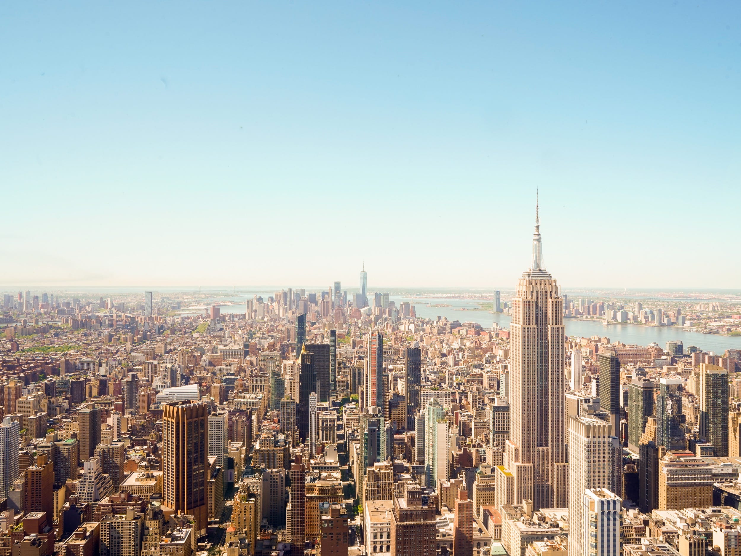 Buildings in Manhattan as seen from the tall One Vanderbilt building against a blue sky.