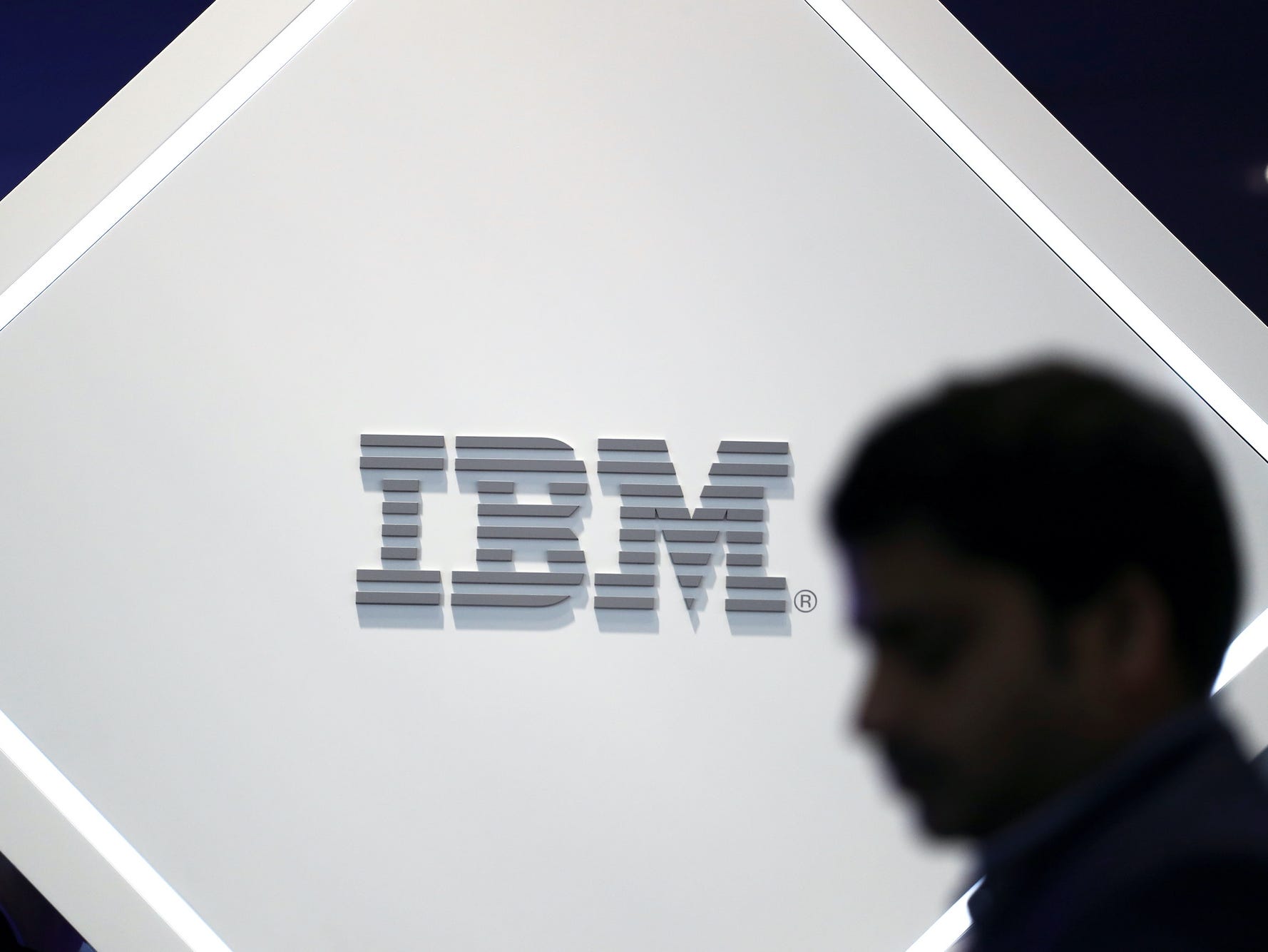 A man stands near an IBM logo