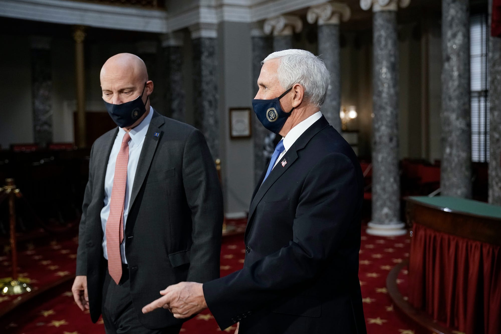 Vice President Mike Pence, joined at left by chief of staff Marc Short, finishes a swearing-in ceremony for senators in the Old Senate Chamber at the Capitol in Washington, Sunday, Jan. 3, 2021.