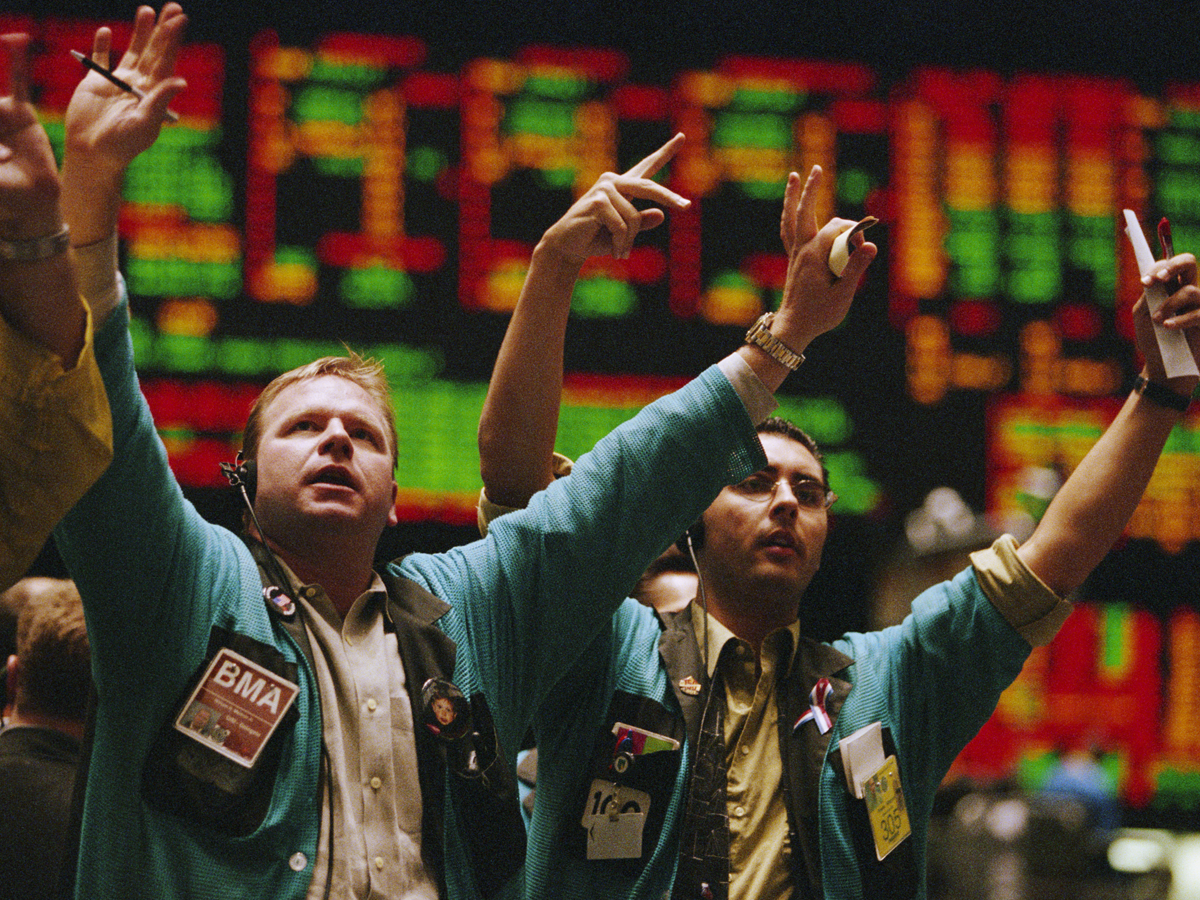 A photo of traders waving their arms on the floor of the New York Stock Exchange.