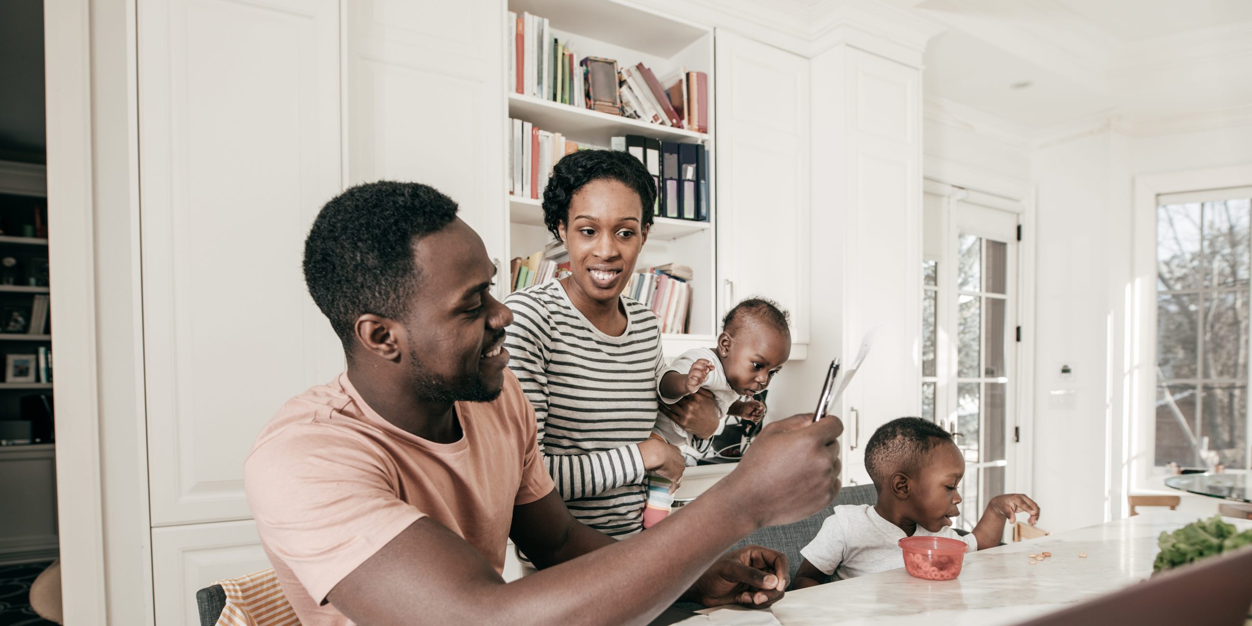 Parents with young children sorting financial paperwork.