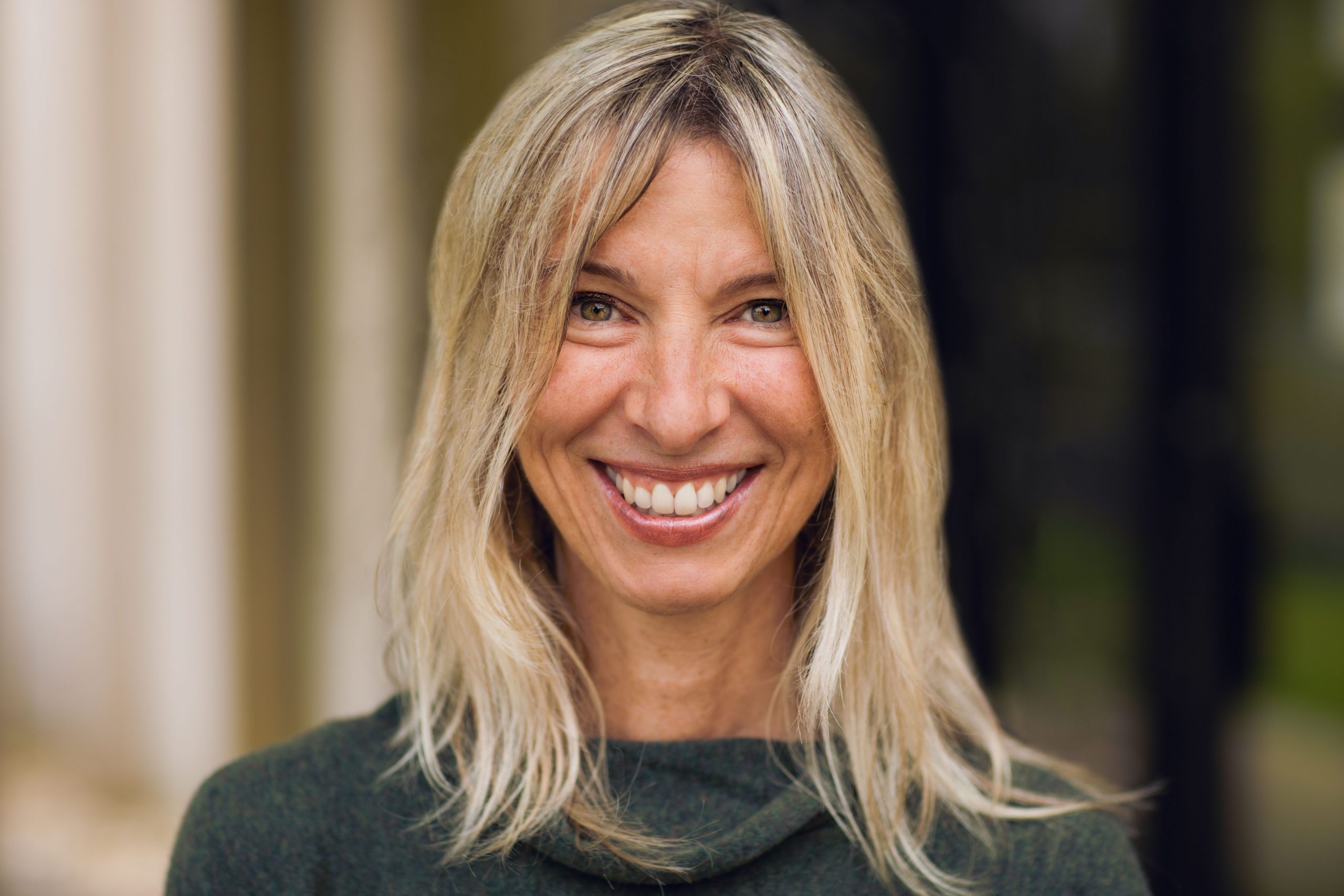 Elizabeth Alterman, who has shoulder-length blonde hair and is smiling into the camera.