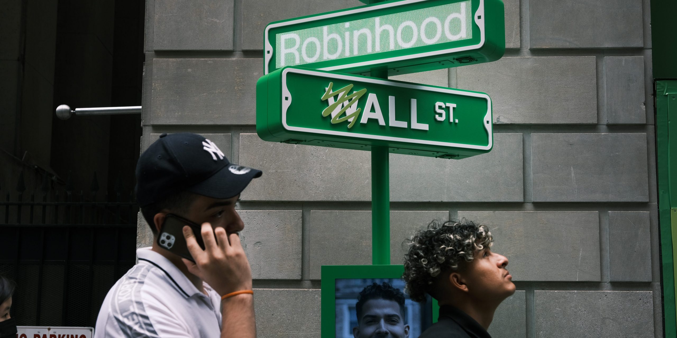 People wait in line for t-shirts at a pop-up kiosk for the online brokerage Robinhood along Wall Street after the company went public with an IPO earlier in the day on July 29, 2021 in New York City.