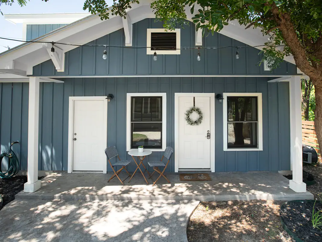 The outside of a small light blue-painted home.