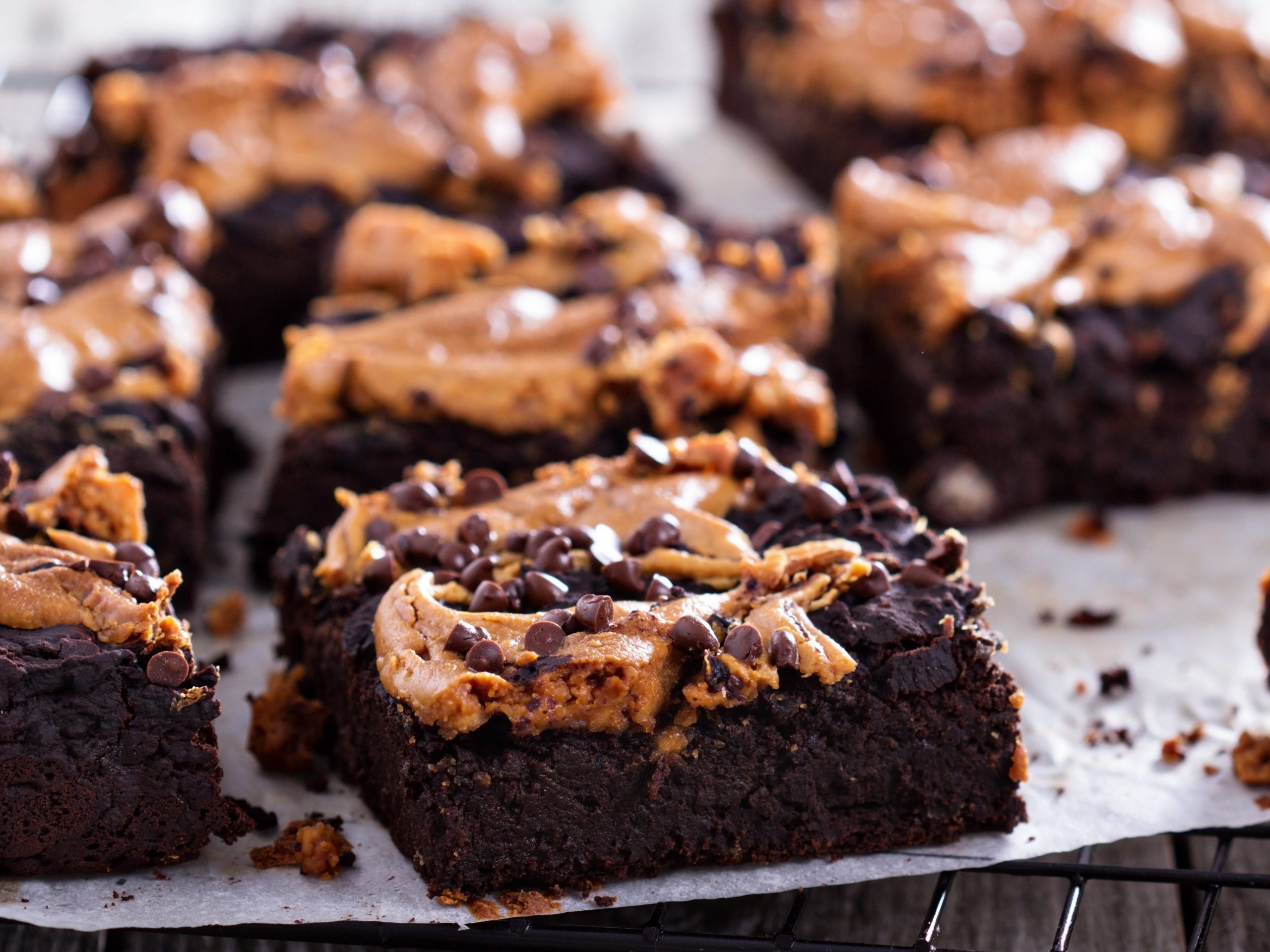 brownies topped with peanut butter and chocolate chips on a cooling rack