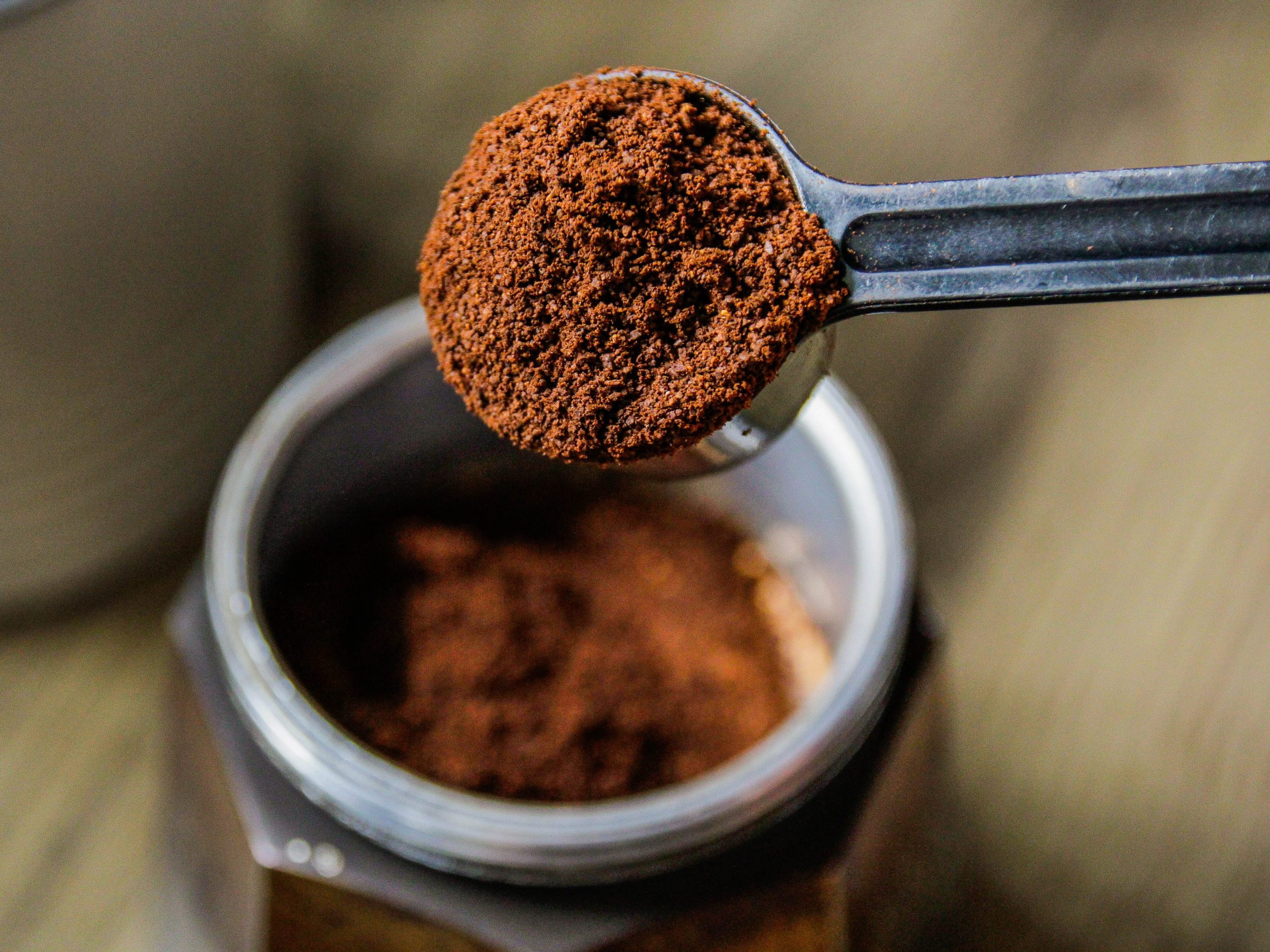 scoop full of espresso powder over a jar of espresso powder