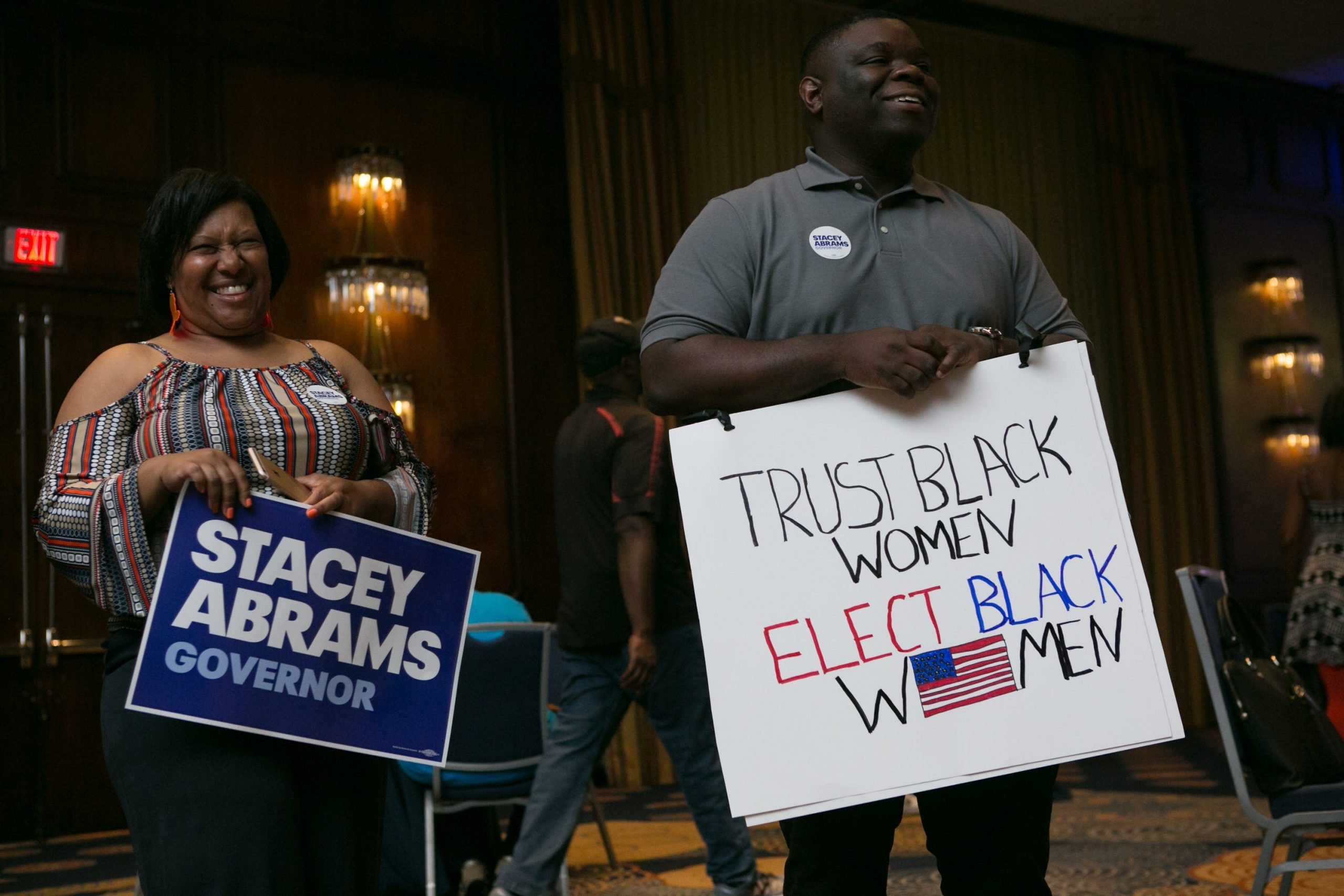 Stacey Abrams supporters stand with signs at a campaign event in 2018.