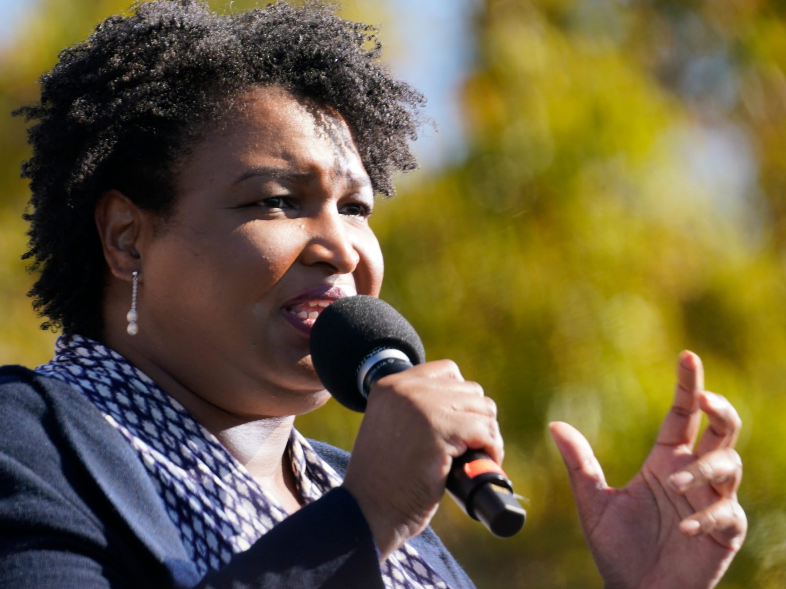 Stacey Abrams speaks into a microphone.