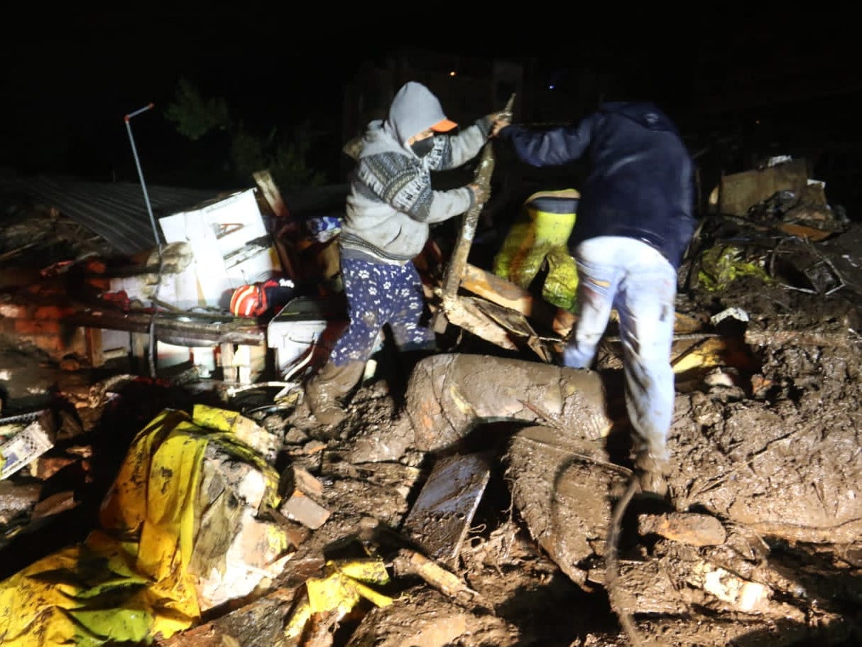 Picture released by Ecuadorean agency API shows people removing debris during the search of victims after a landslide caused by heavy rains in Quito, on January 31, 2022