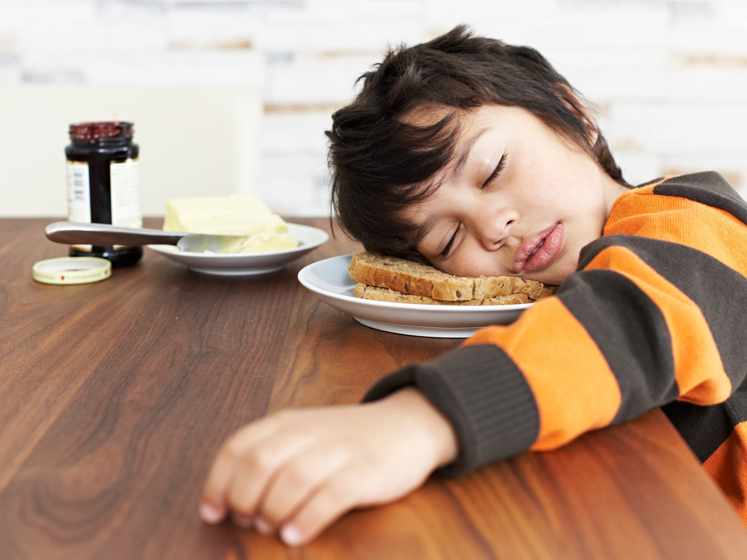 Child falling asleep in his breakfast