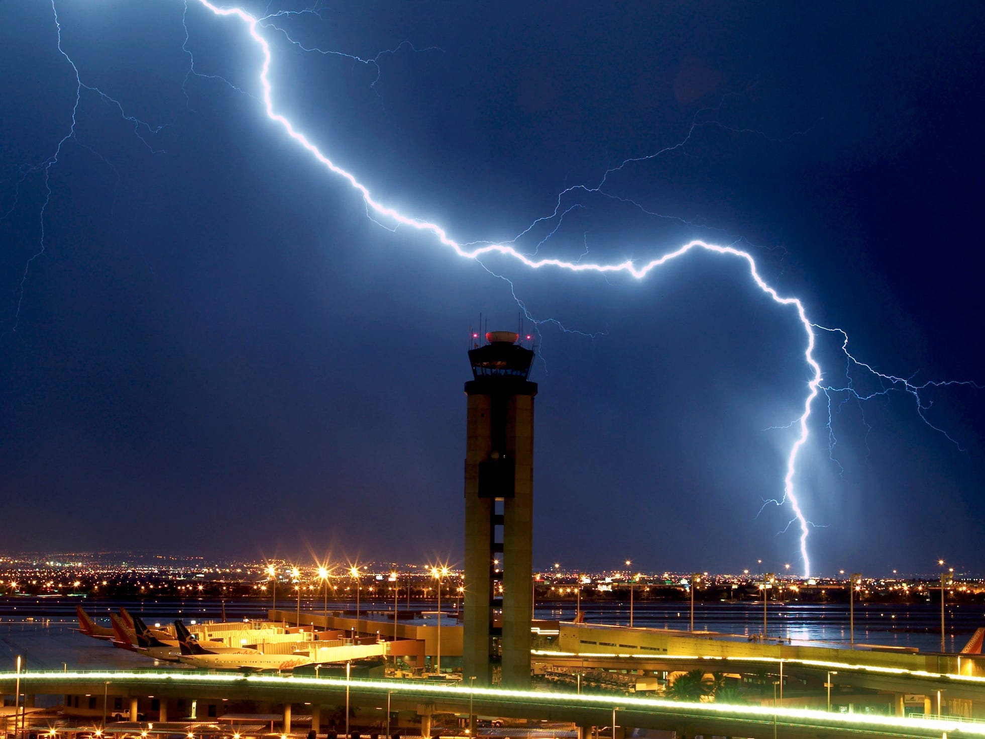 lightning bolt above tower in city at night