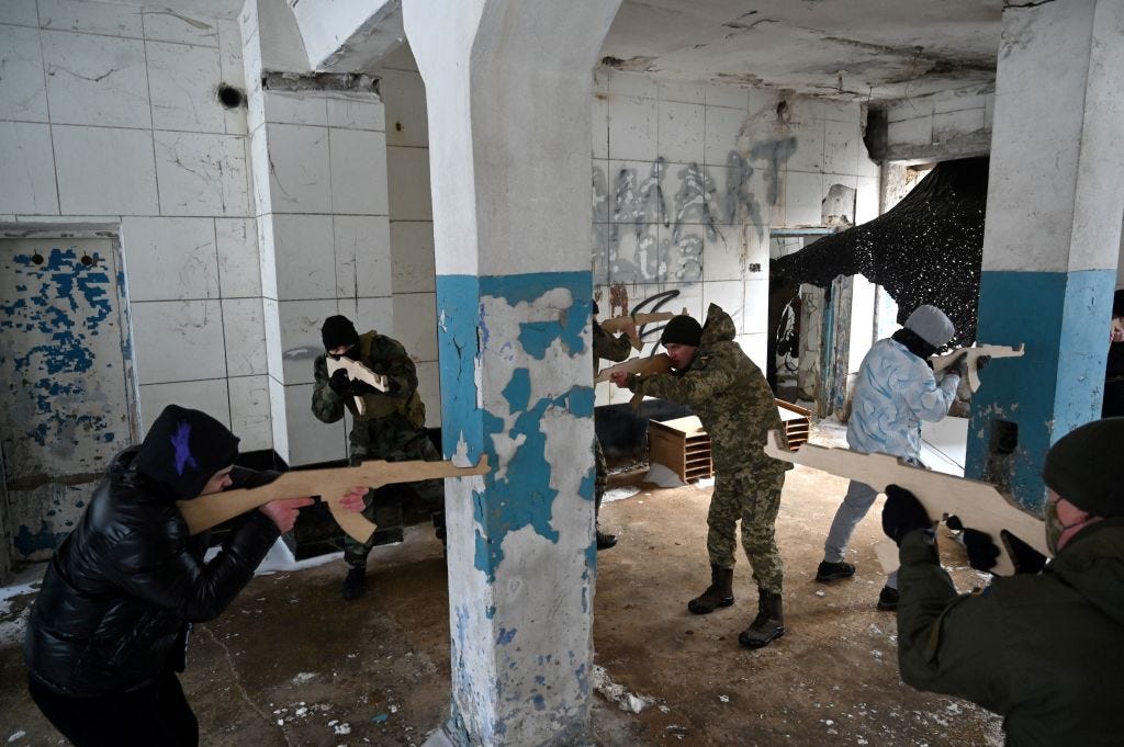 Civilians hold wooden replicas of Kalashnikov rifles, during a training session at an abandoned factory in the Ukrainian capital of Kyiv on January 30, 2022.