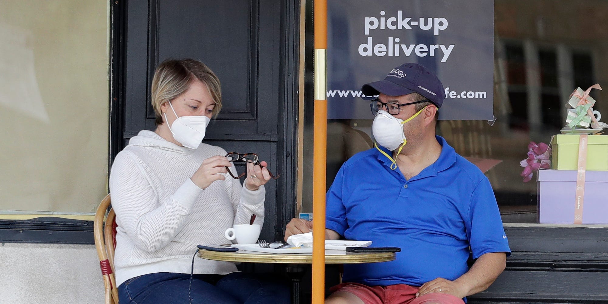 People wear mask after eating outside of a restaurant in Evanston, Ill., Friday, May 29, 2020.