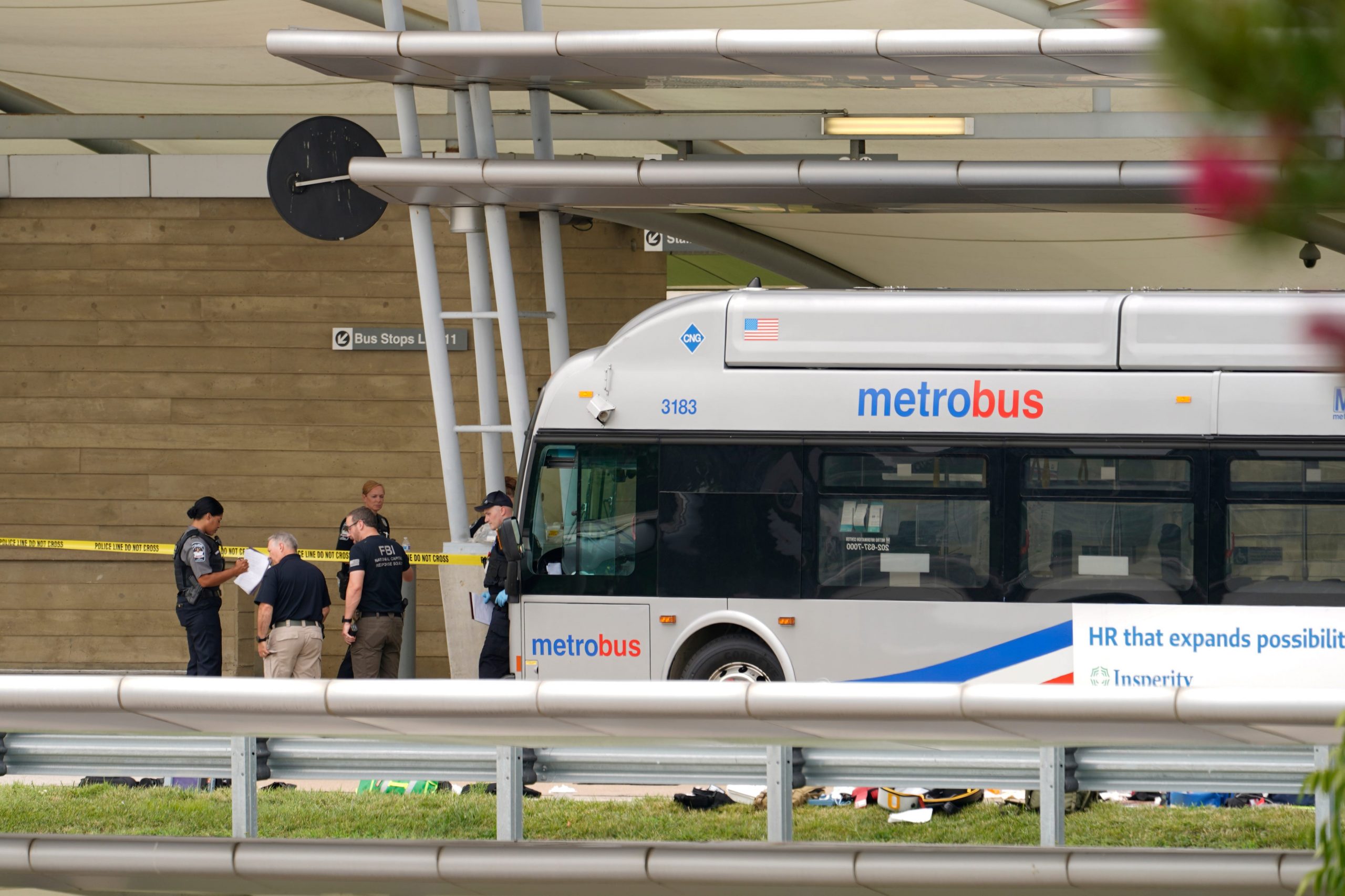 Police are looking at a scene and items are seen on the ground near a Metrobus outside the Pentagon Metro area.