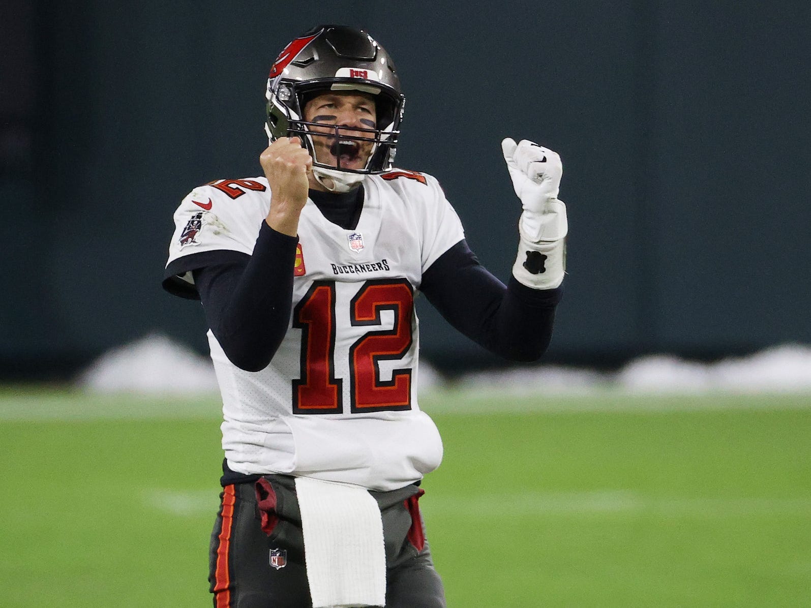 Tom Brady pumps his fists and celebrates during a game in 2021.