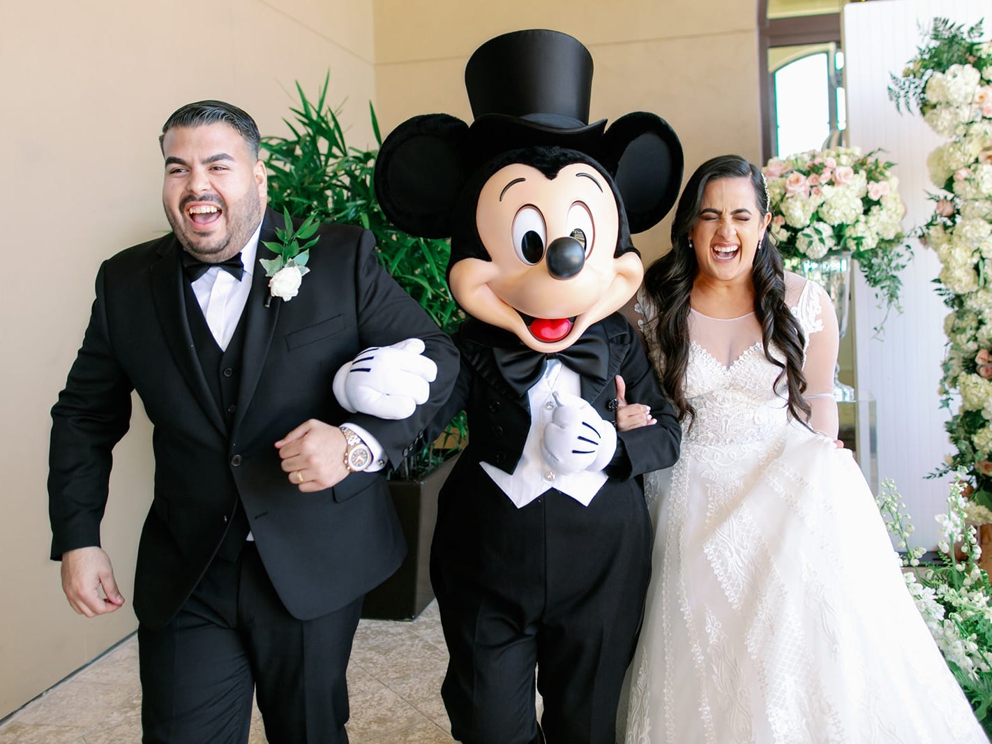 stephanie and her husband posing with mickey mouse at their disney wedding