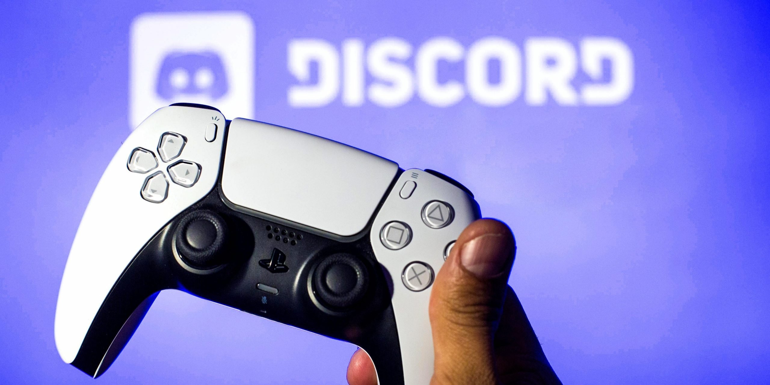 In this photo illustration, a PlayStation 5 controller seen with a Discord logo in the background.