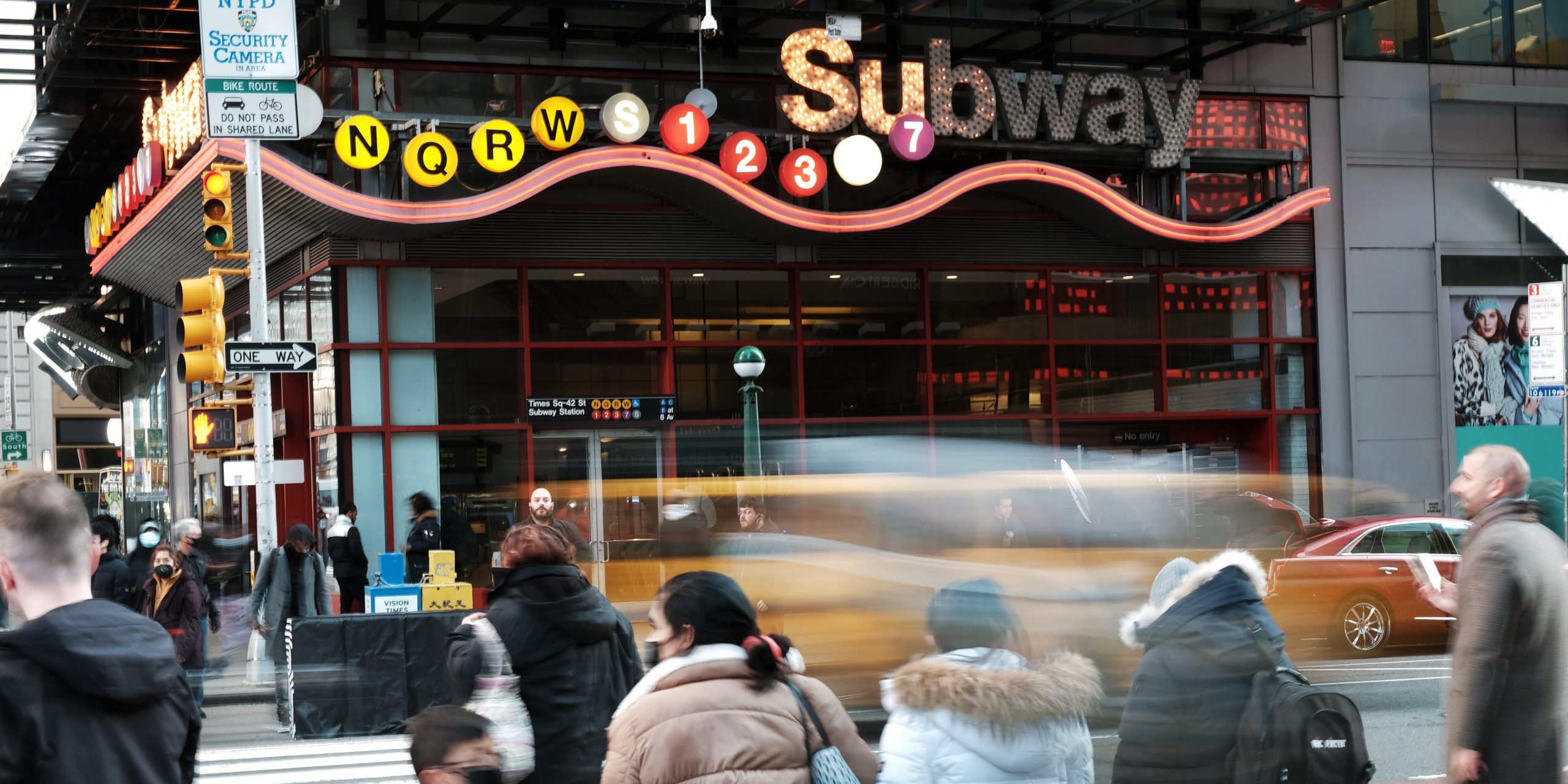 People stand outside a subway station in Times Square, New York City