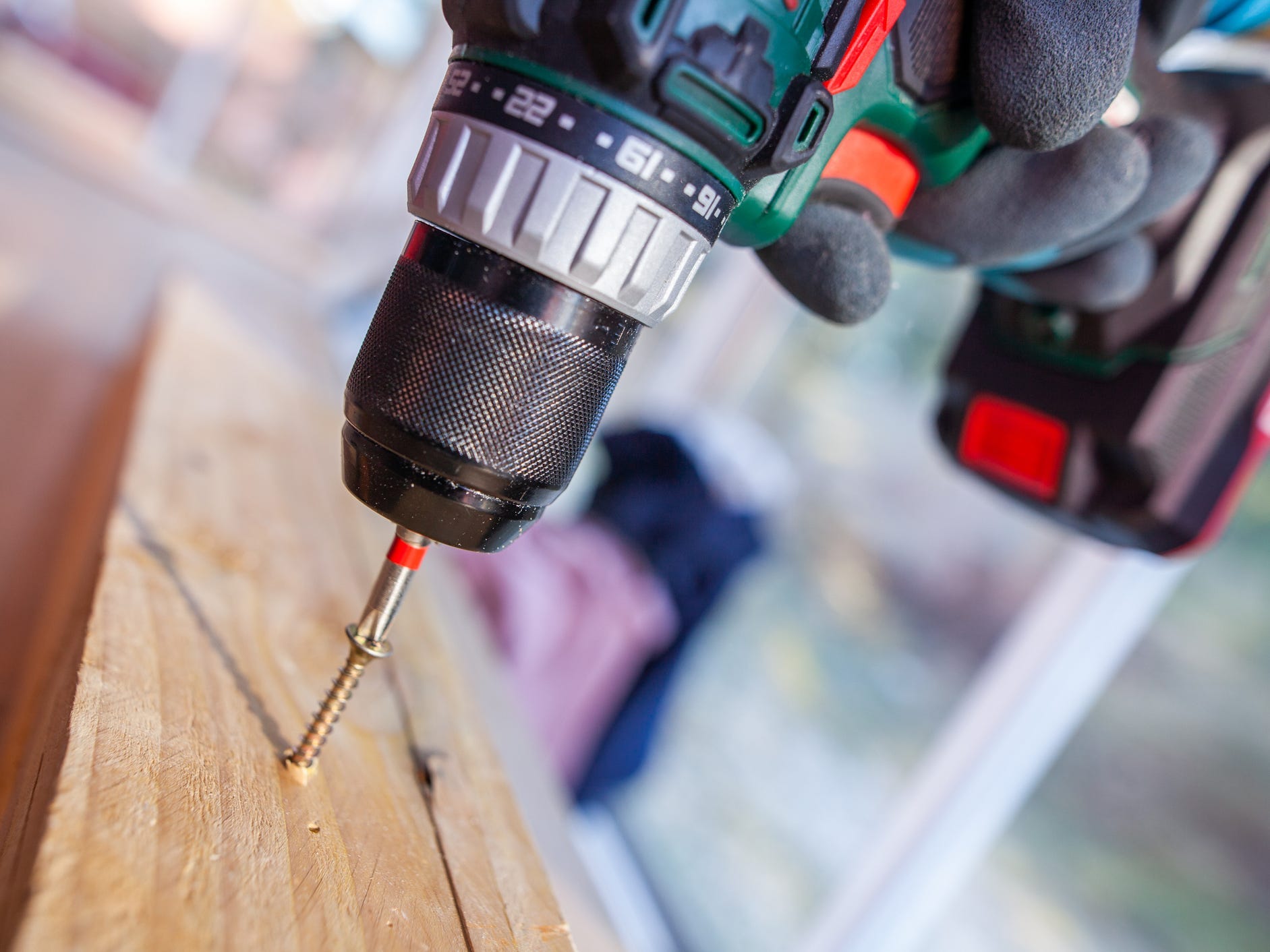 A drill driving a screw into a piece of wood