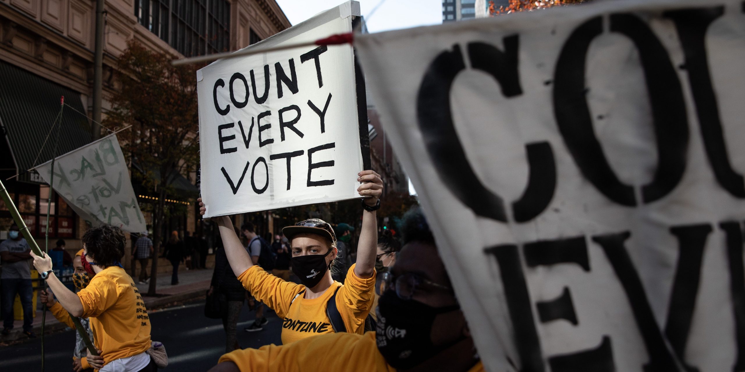 protester holding sign that says "count every vote"