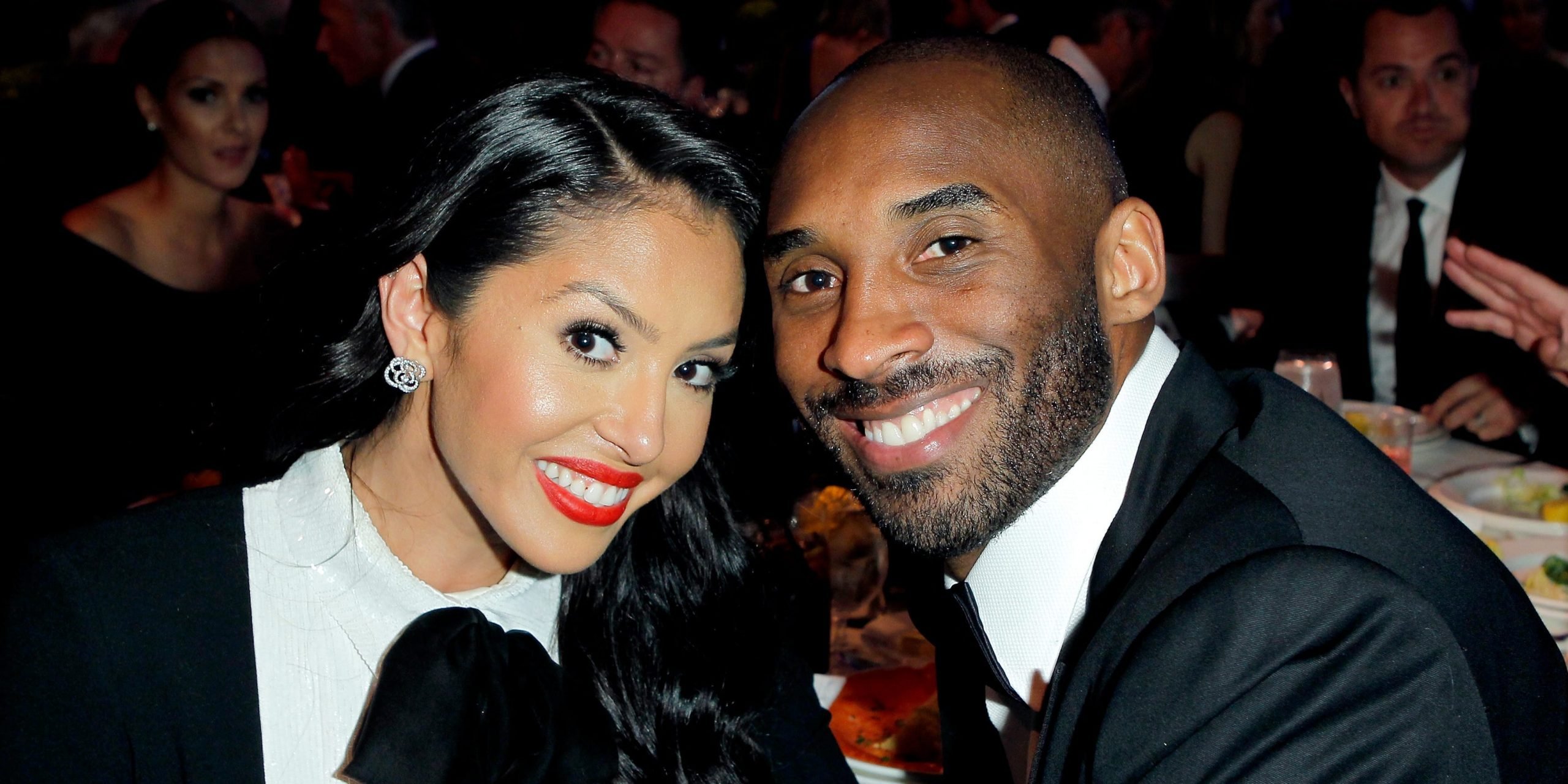 Vanessa Bryant (left) and Kobe Bryant (right) touching heads to pose for a photo in black and white attire