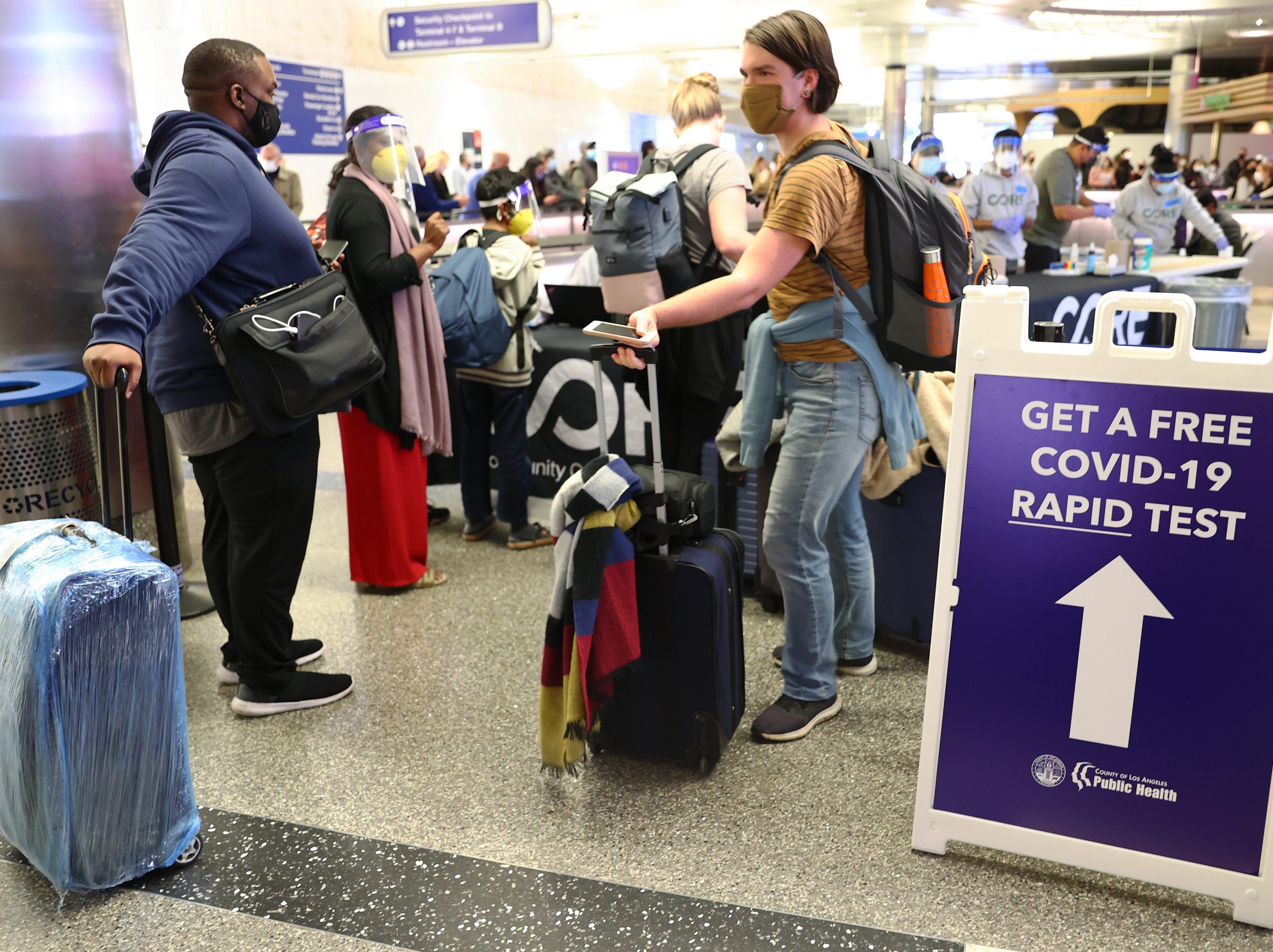 People with luggage at the LAX airport Covid-19 testing station