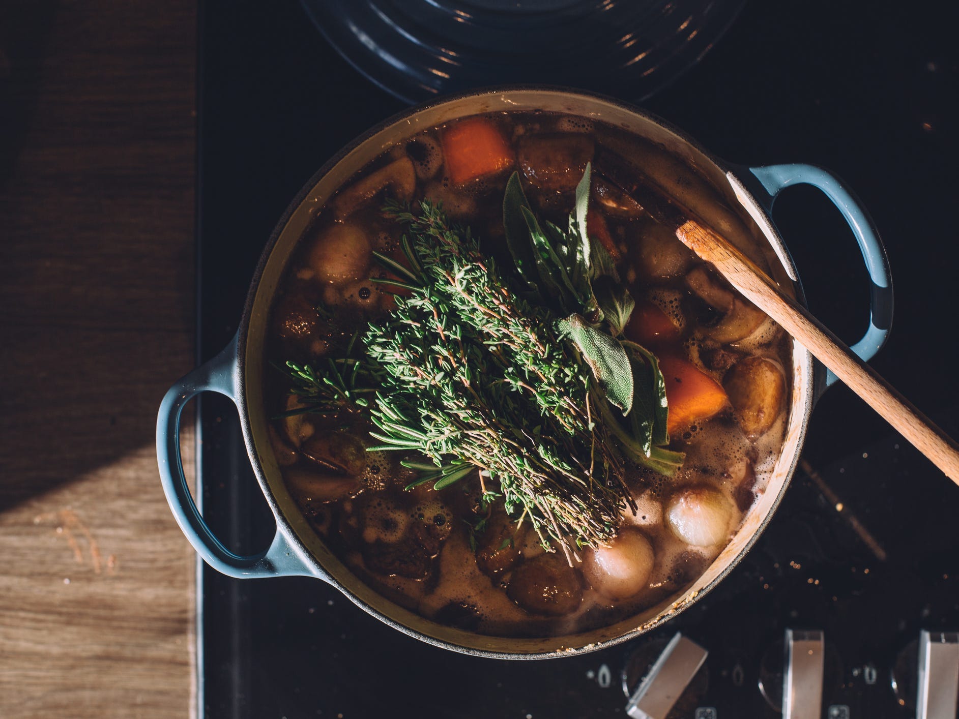 Overhead shot of stew cooking with herbs on top