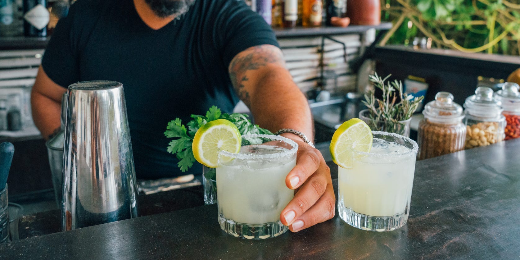 A bartender serving margaritas