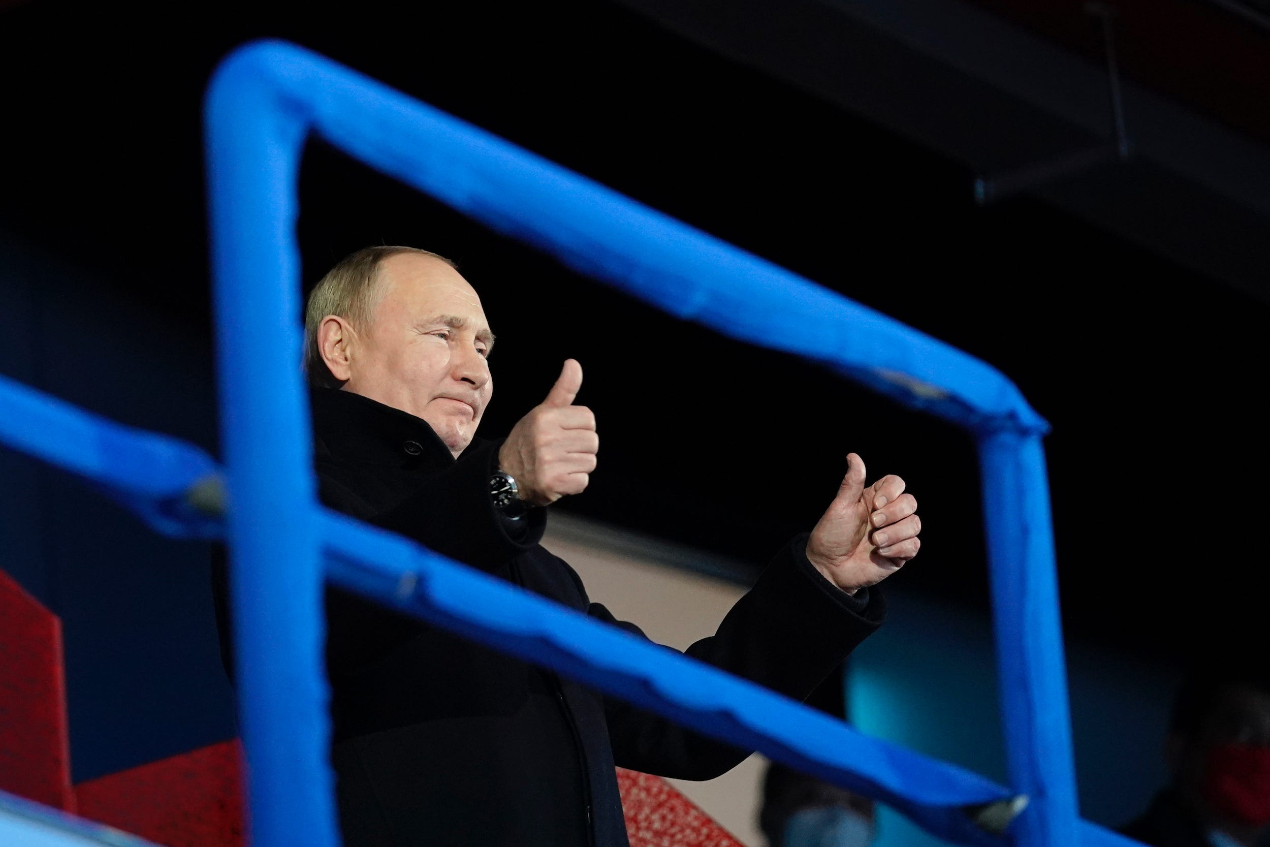 Russian President Vladimir Putin stands and gestures as the Russian Olympic Committee athletes arrive at this year's Opening Ceremony.
