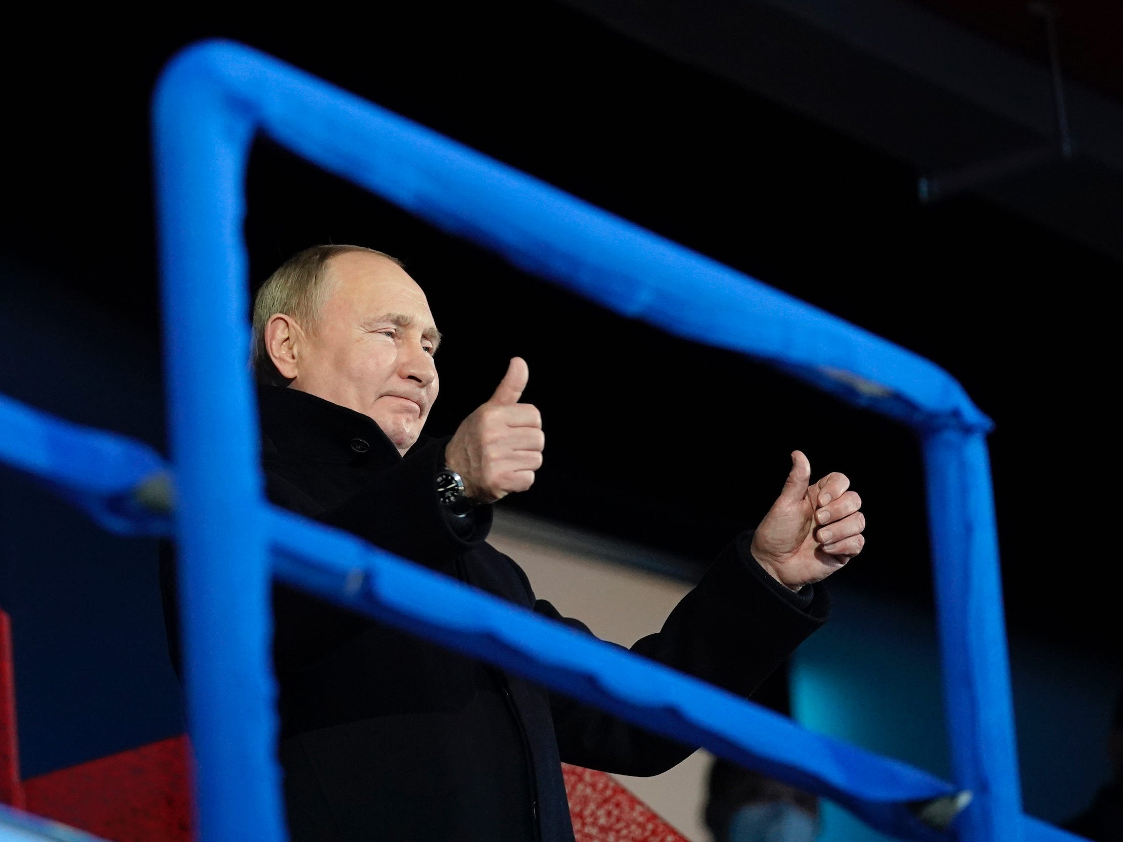 Russian President Vladimir Putin stands and gestures as the Russian Olympic Committee athletes arrive at this year's Opening Ceremony.
