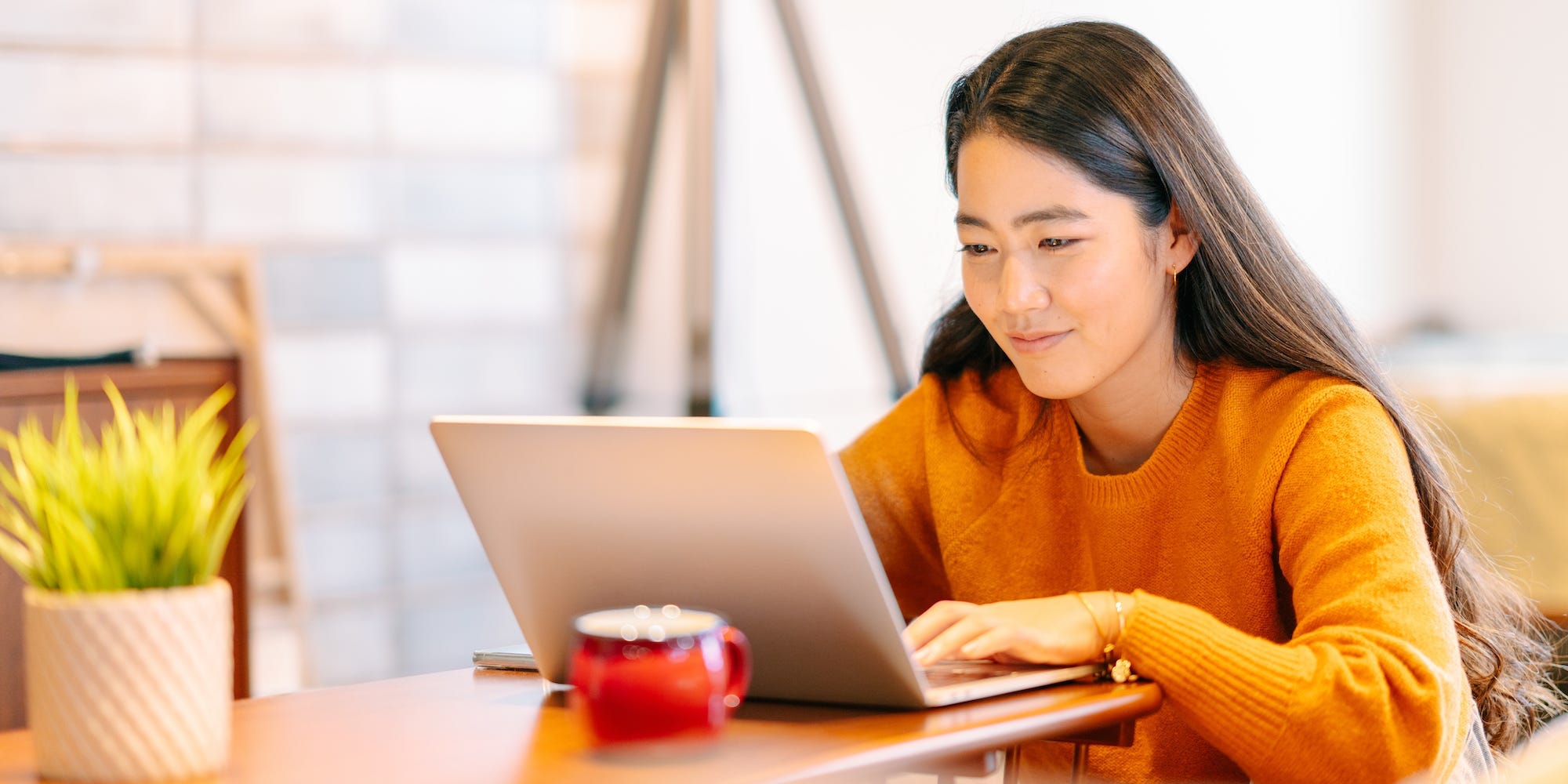 a woman working from home and using her laptop