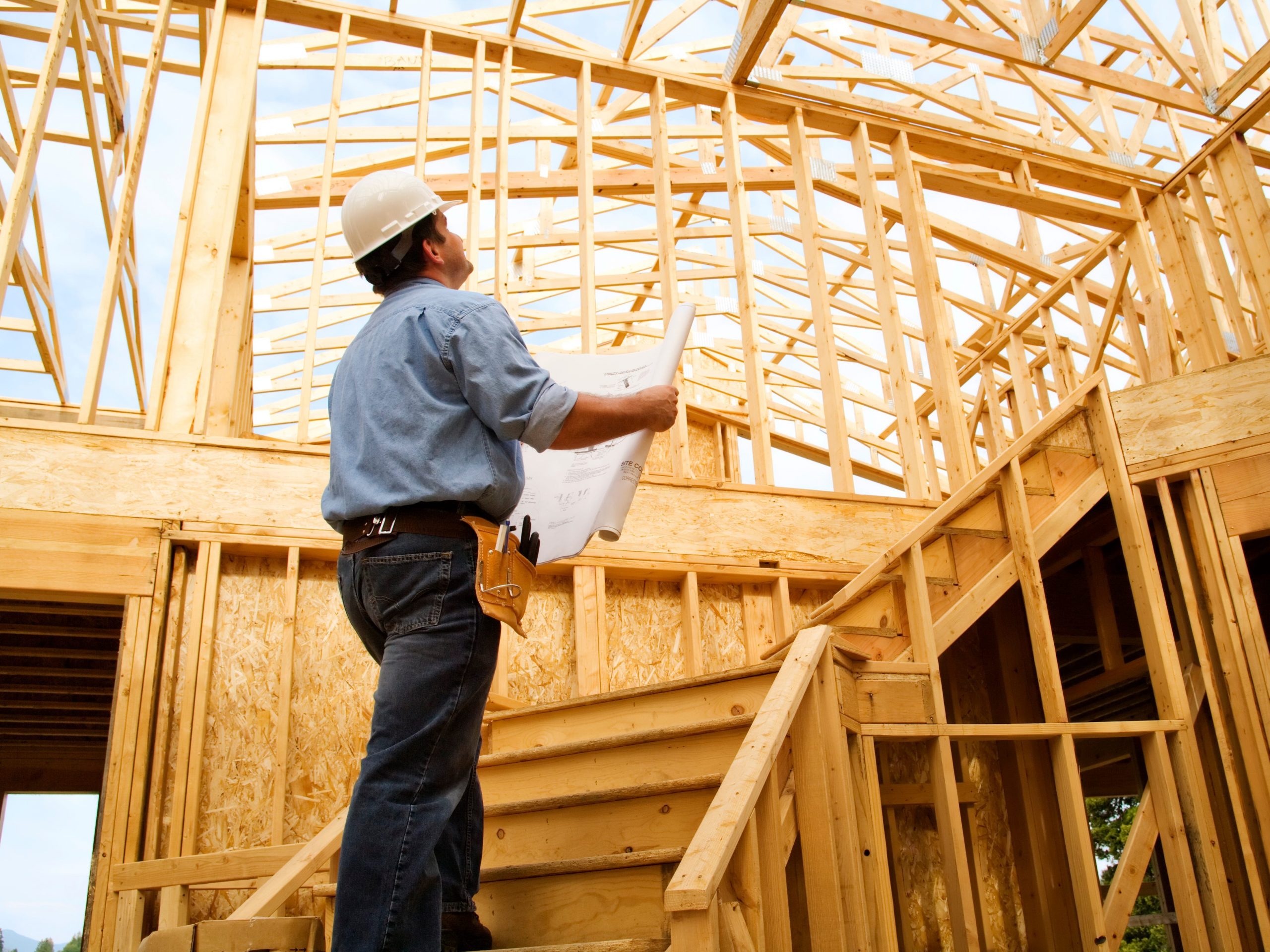 Construction worker observing a house.